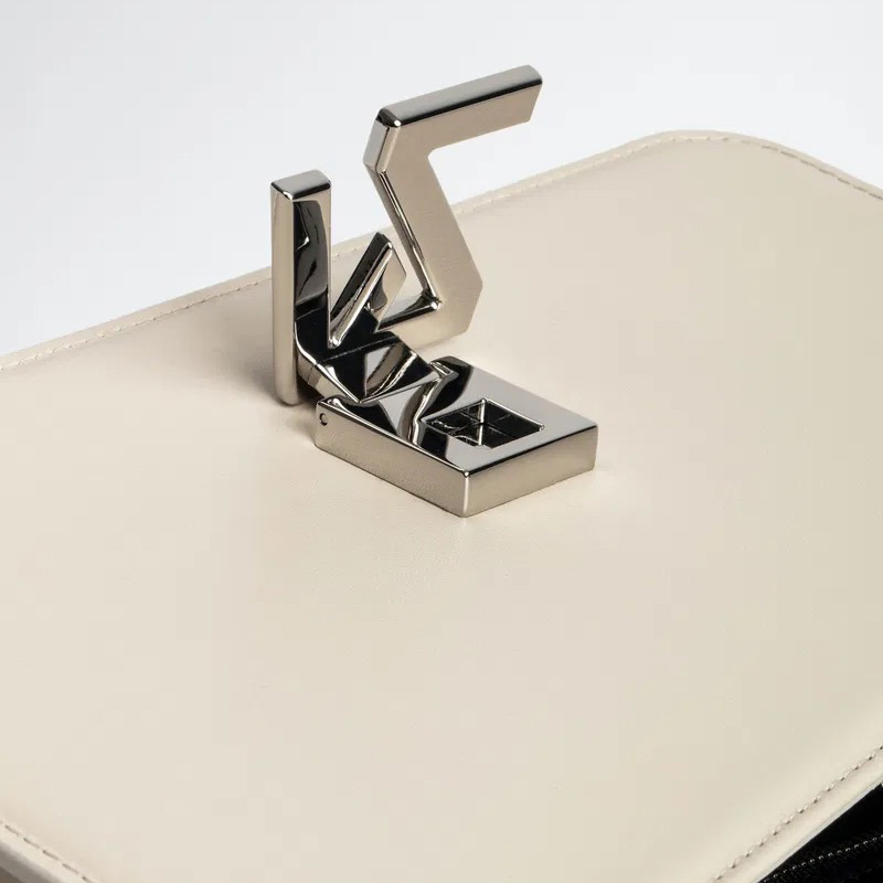 Fecho metálico prateado sobre couro bege claro