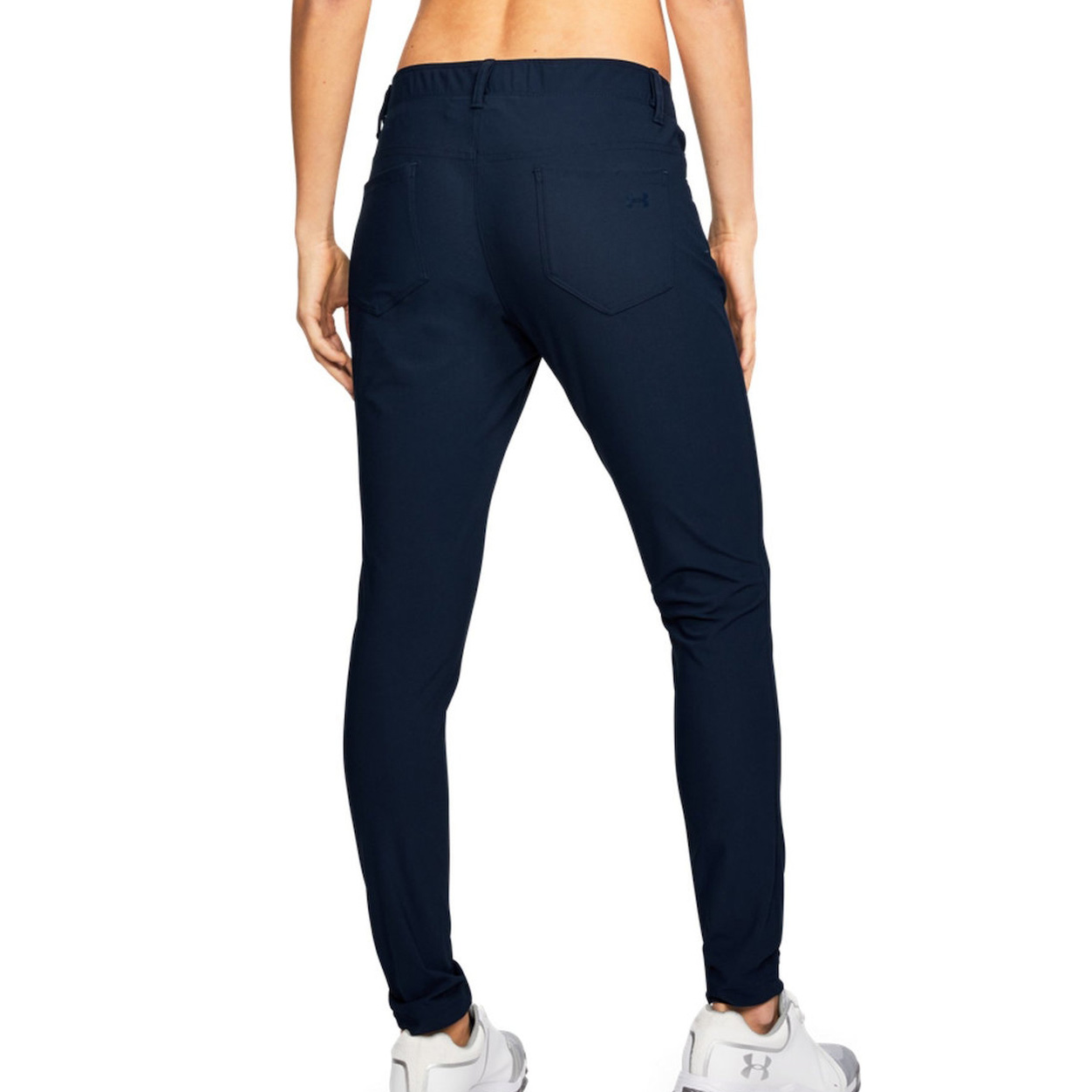 Calças desportivas azul escuro femininas vistas de trás com sapatilhas brancas e cinzentas