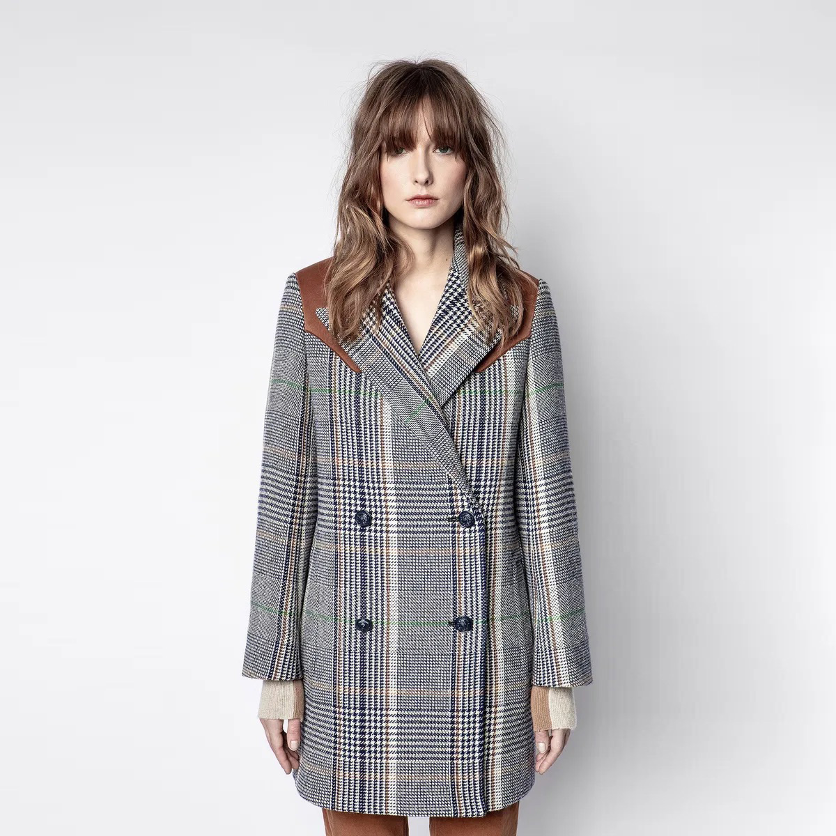 Casaco comprido xadrez com detalhes em pele castanha nos ombros.