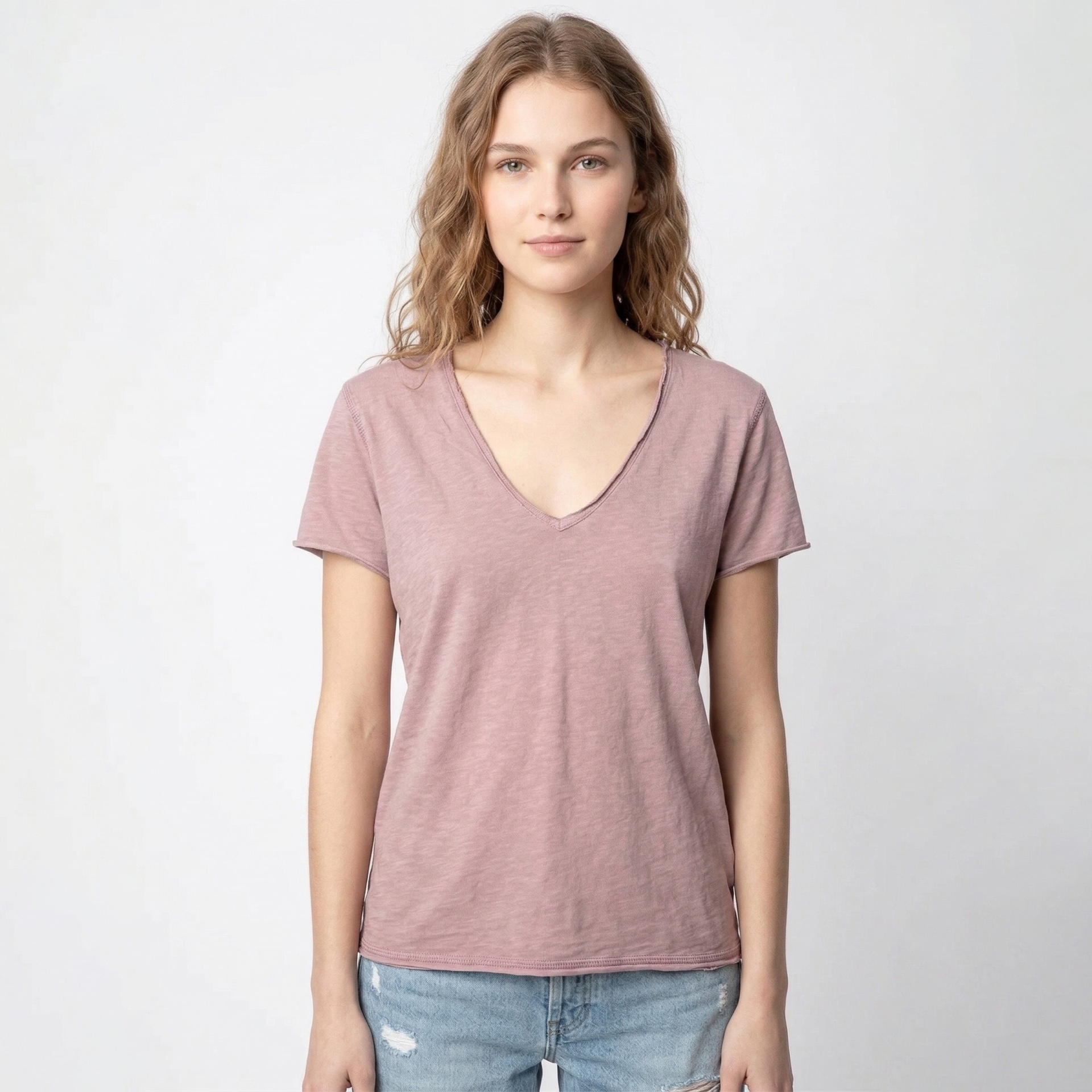 T-shirt rosa claro de algodão com decote em V e mangas curtas usada por mulher
