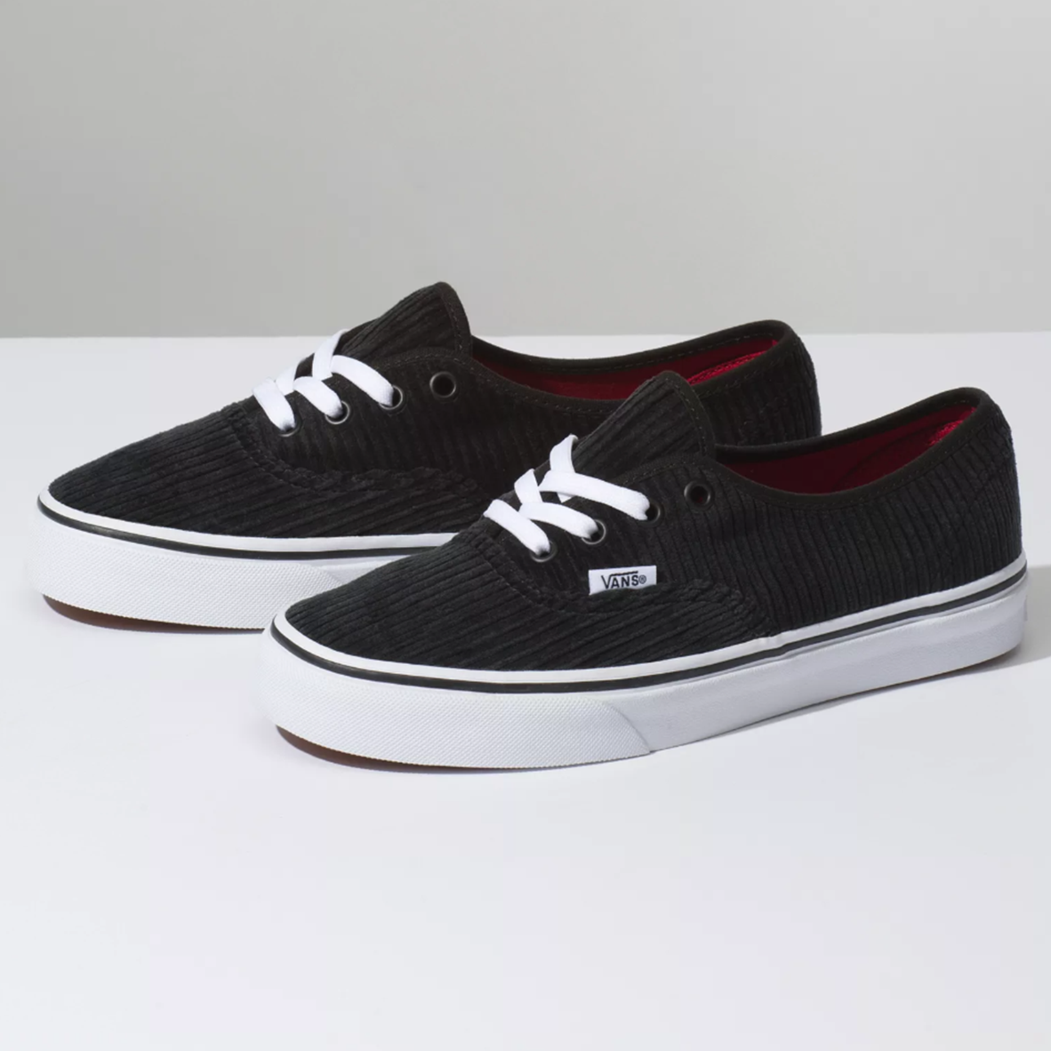 Ténis Vans pretos em veludo cotelê com sola e atacadores brancos, interior vermelho