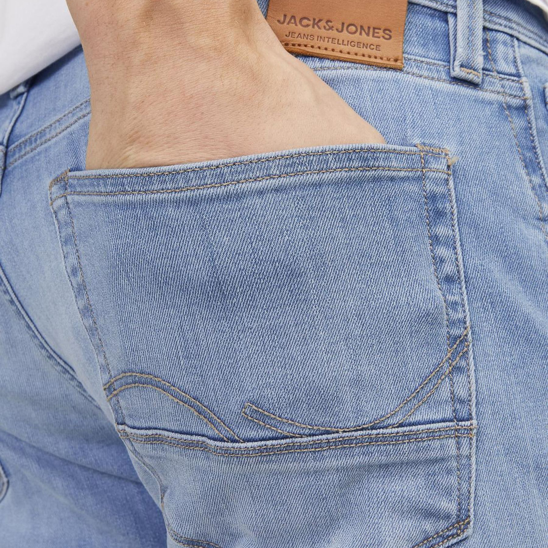 Calças de ganga azul claro com etiqueta JACK & JONES e mão no bolso