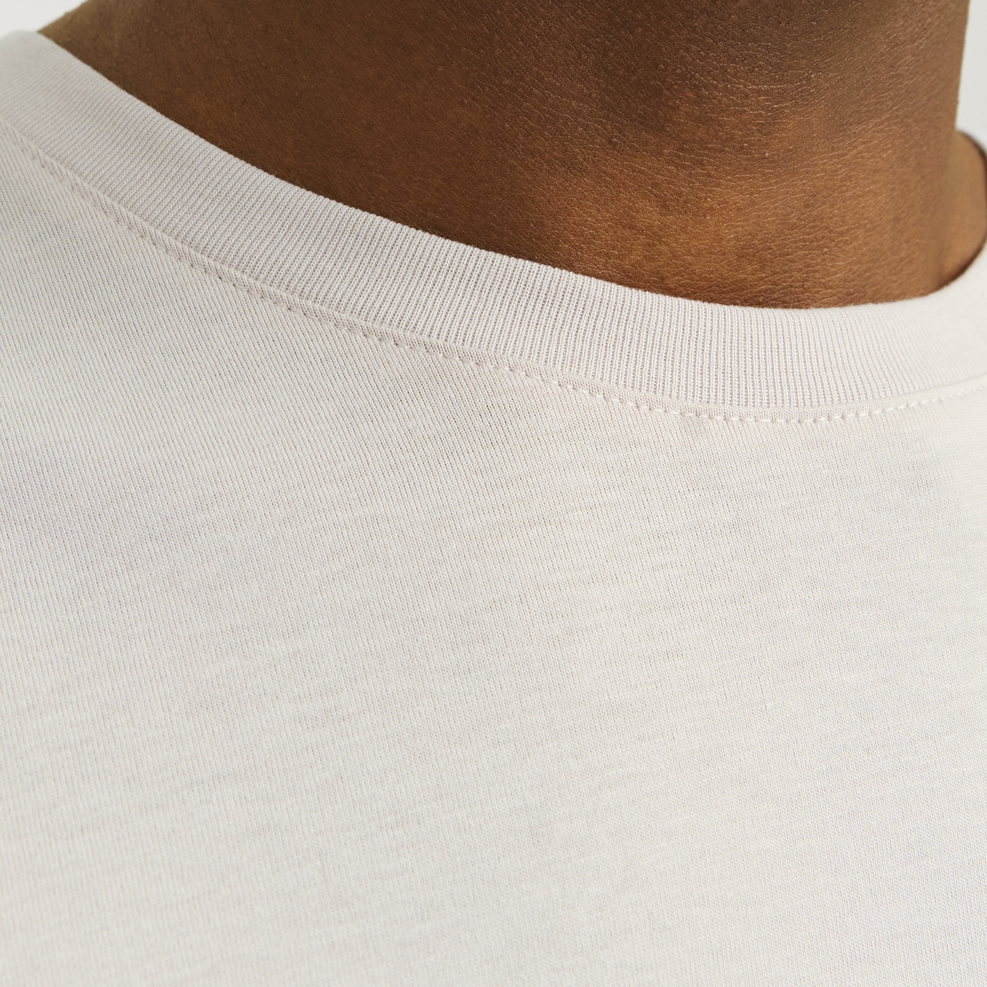 Gola redonda de t-shirt creme claro em close-up