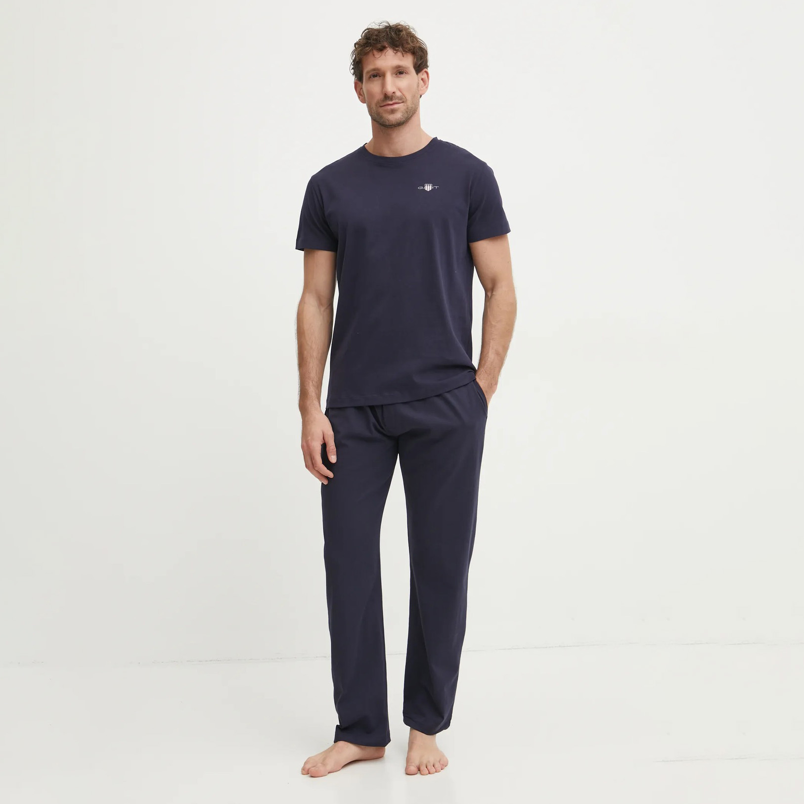 Homem com pijama azul escuro de manga curta e calças compridas com o texto GIANT