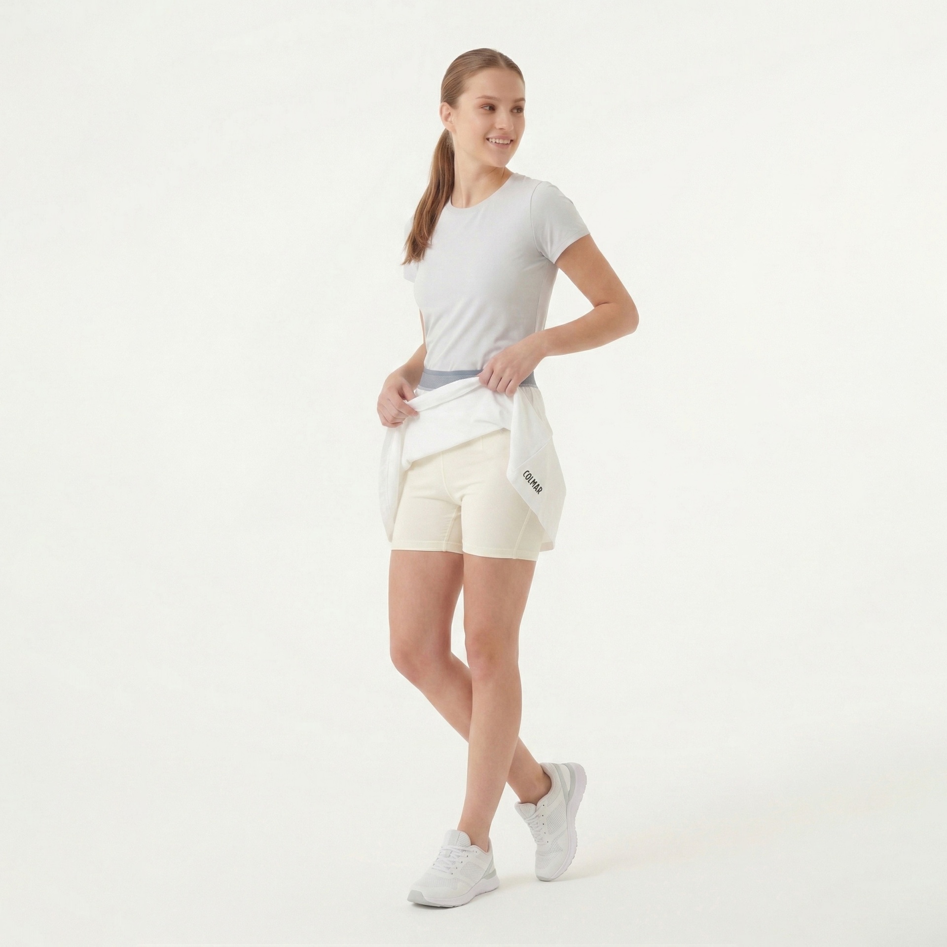 Mulher com roupa desportiva branca e bege clara