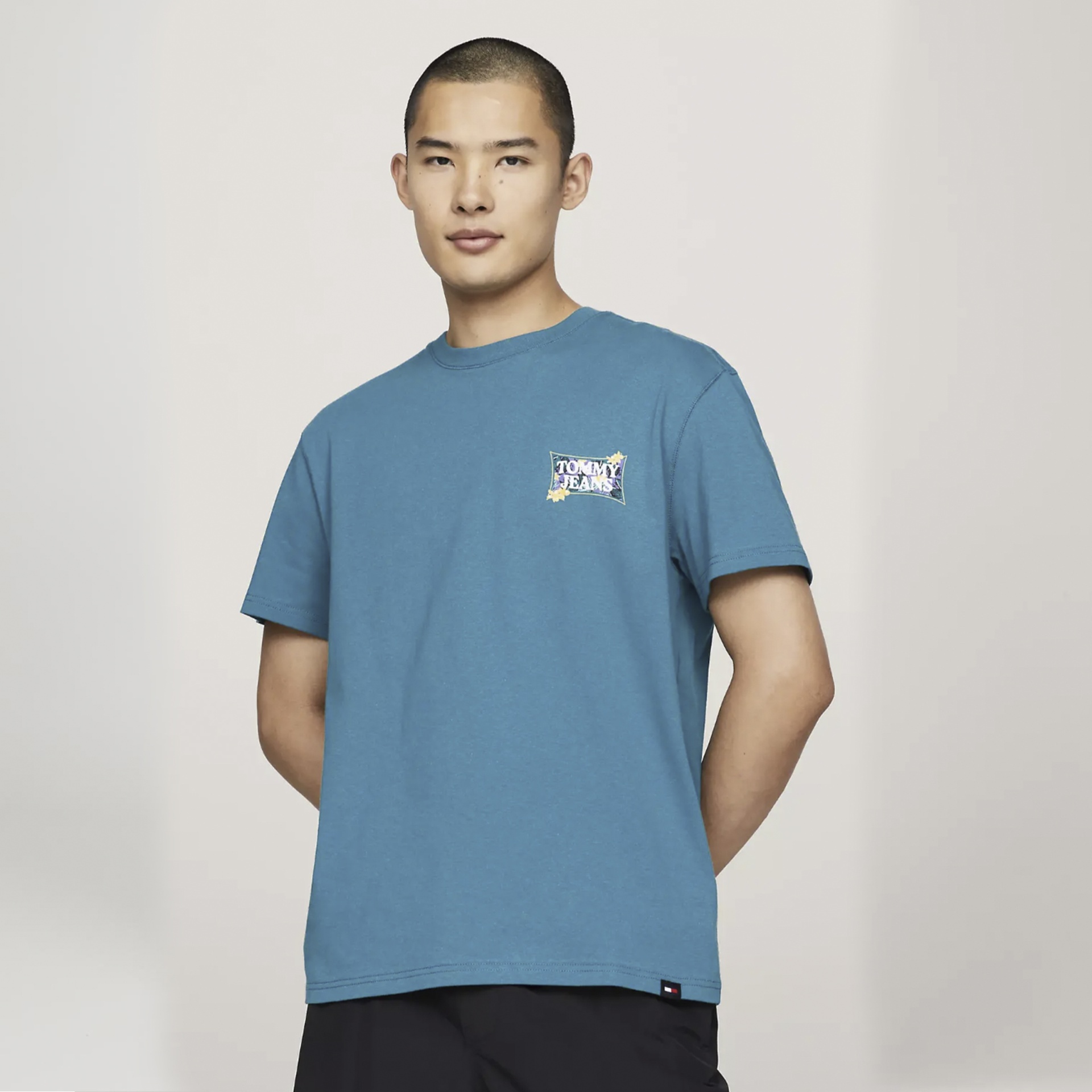 Camiseta azul com logótipo pequeno usada por modelo masculino