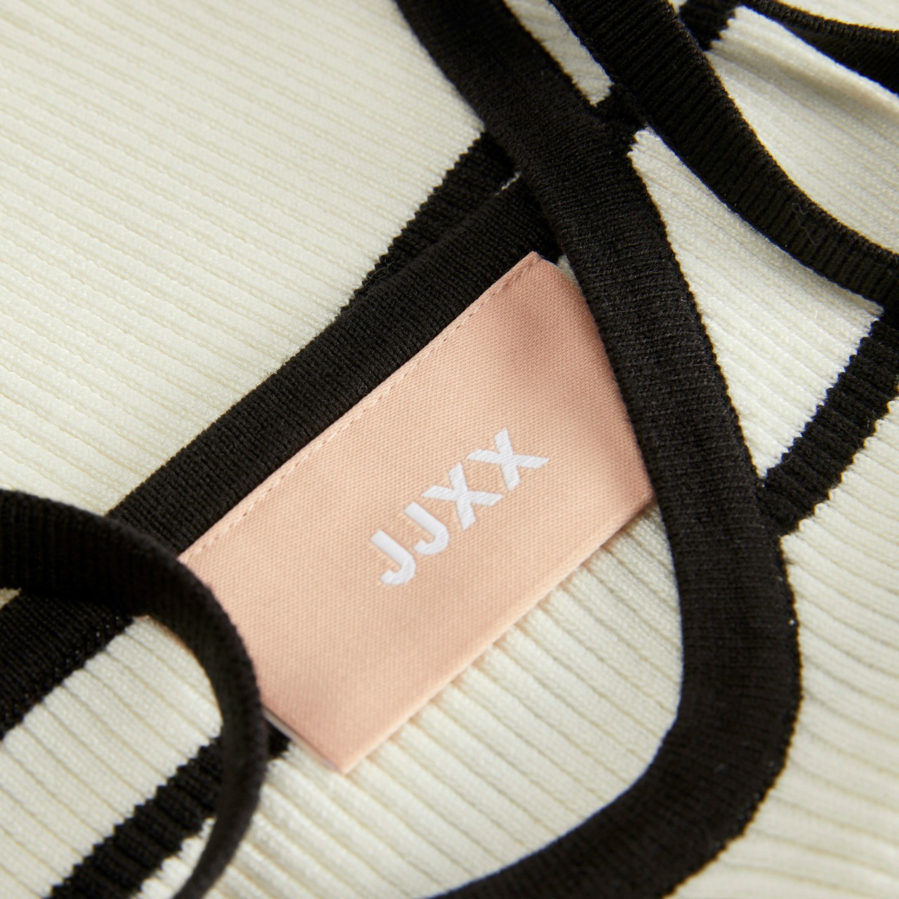 Etiqueta JJXX em roupa clara com bordas pretas