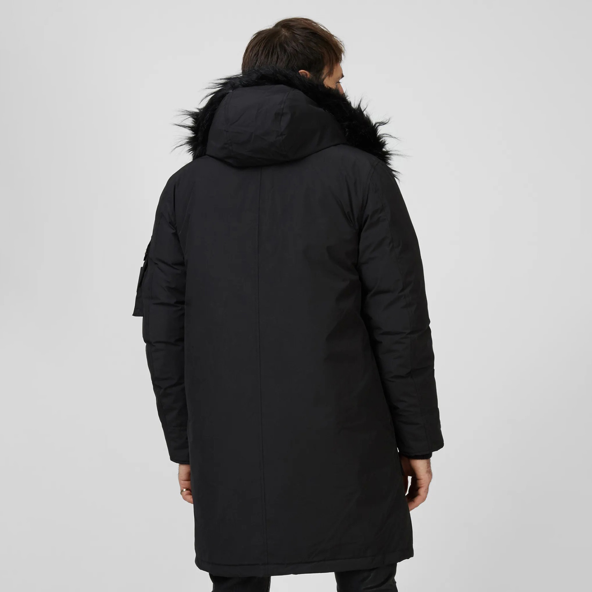 Parka preta com capuz e pêlo sintético na borda do capuz vista de costas.