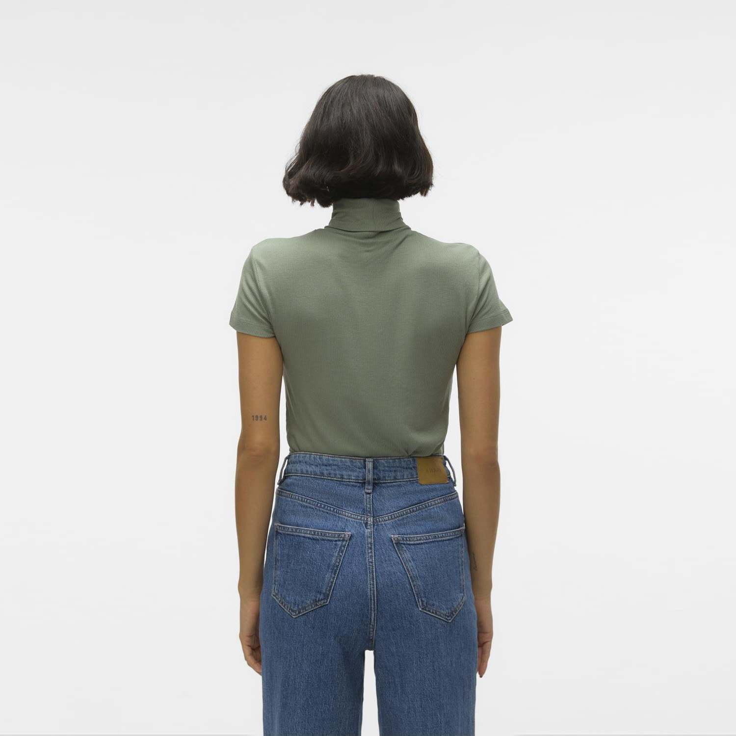 Camisola verde canelada de manga curta e jeans azuis vistos de costas