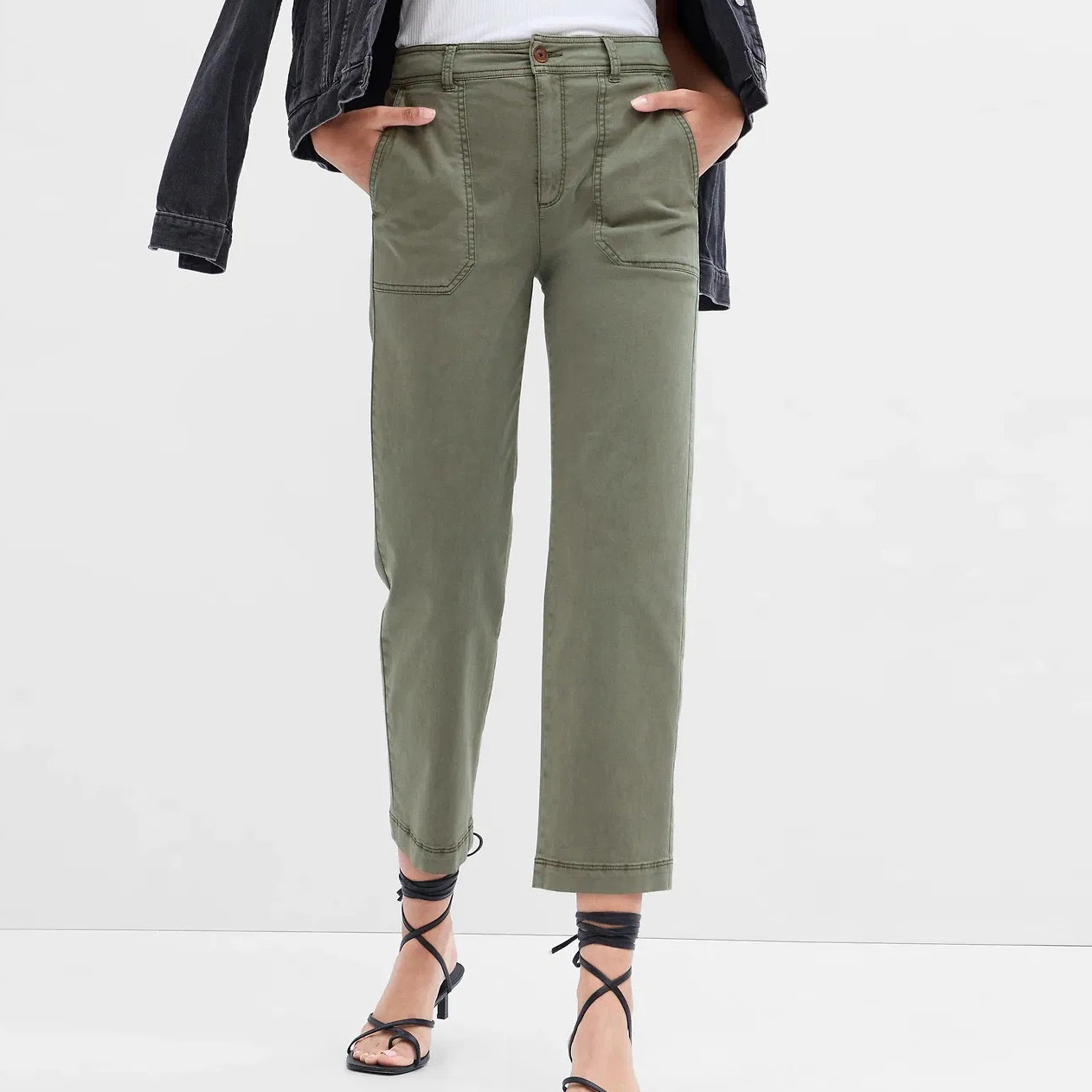 Calças verdes com bolsos grandes e sandálias pretas de tiras.