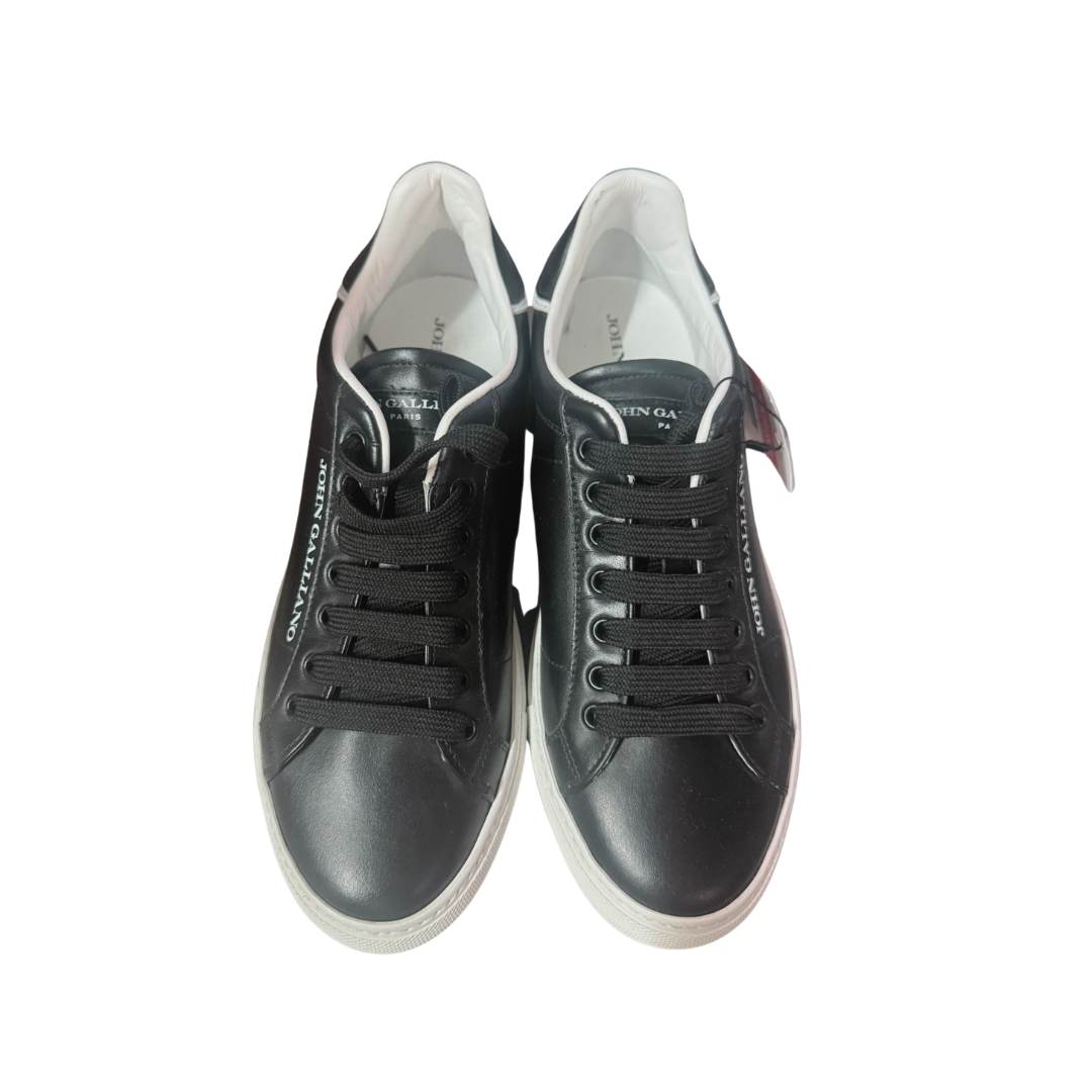 Ténis pretos em pele com sola branca e atacadores pretos