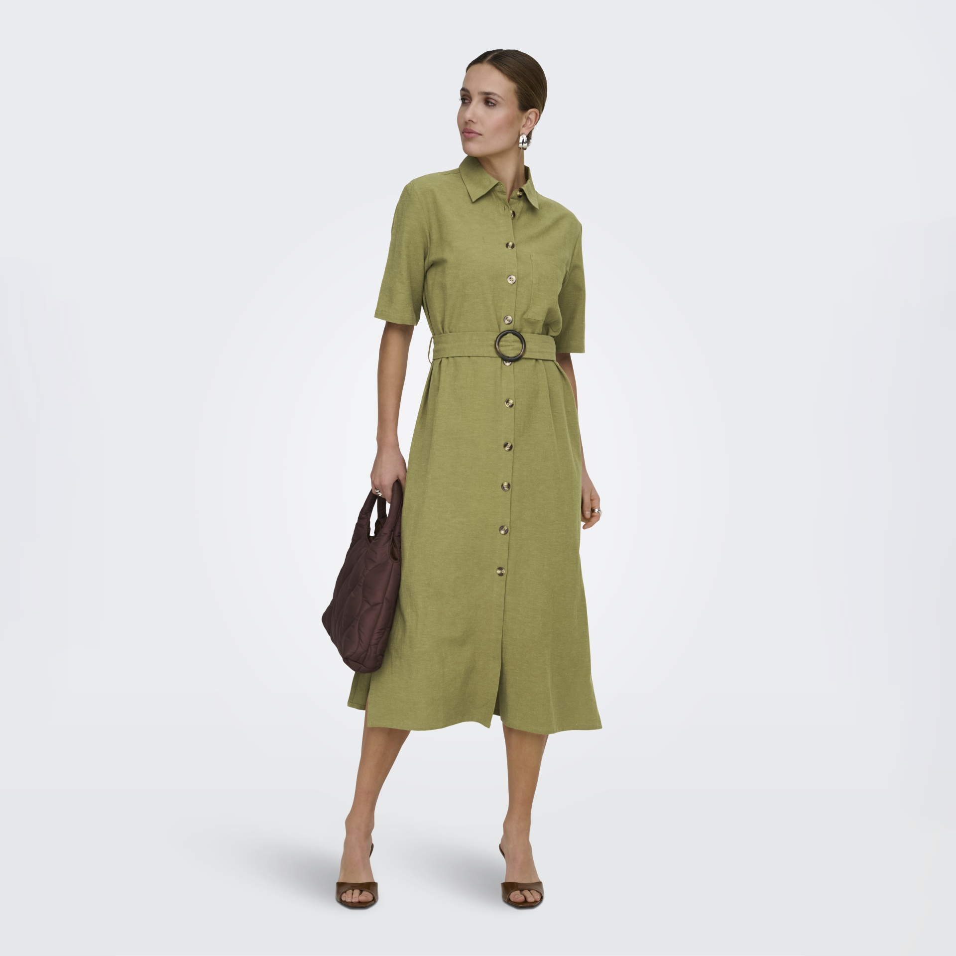 Vestido verde com botões e cinto usado por mulher com mala castanha