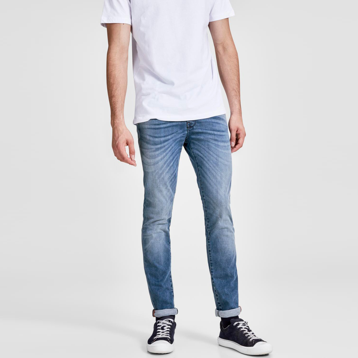Jeans masculinos azuis com t-shirt branca e sapatilhas pretas