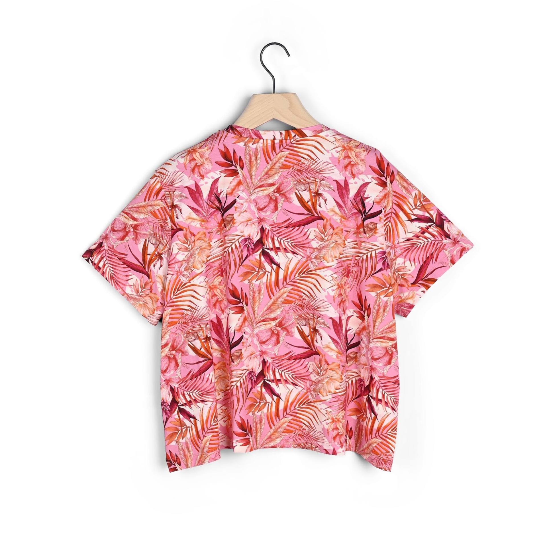 Camisa de manga curta rosa com padrão tropical pendurada num cabide
