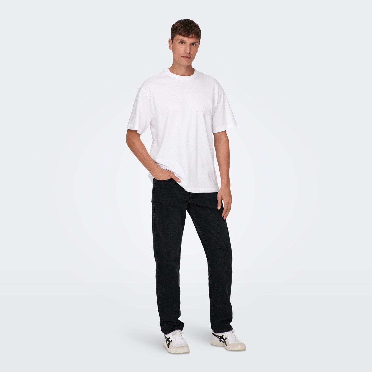 Homem com t-shirt branca e calças pretas em fundo branco