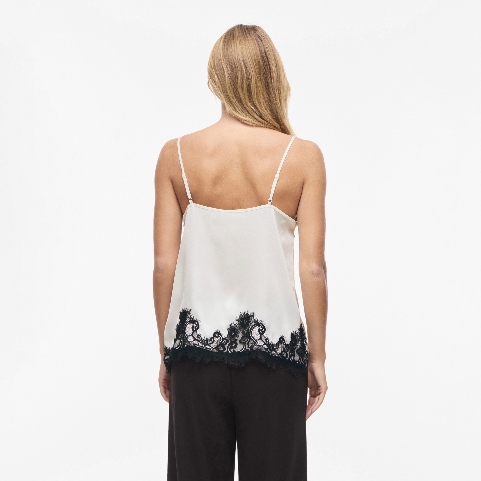 Blusa branca com renda preta na parte inferior vista de costas
