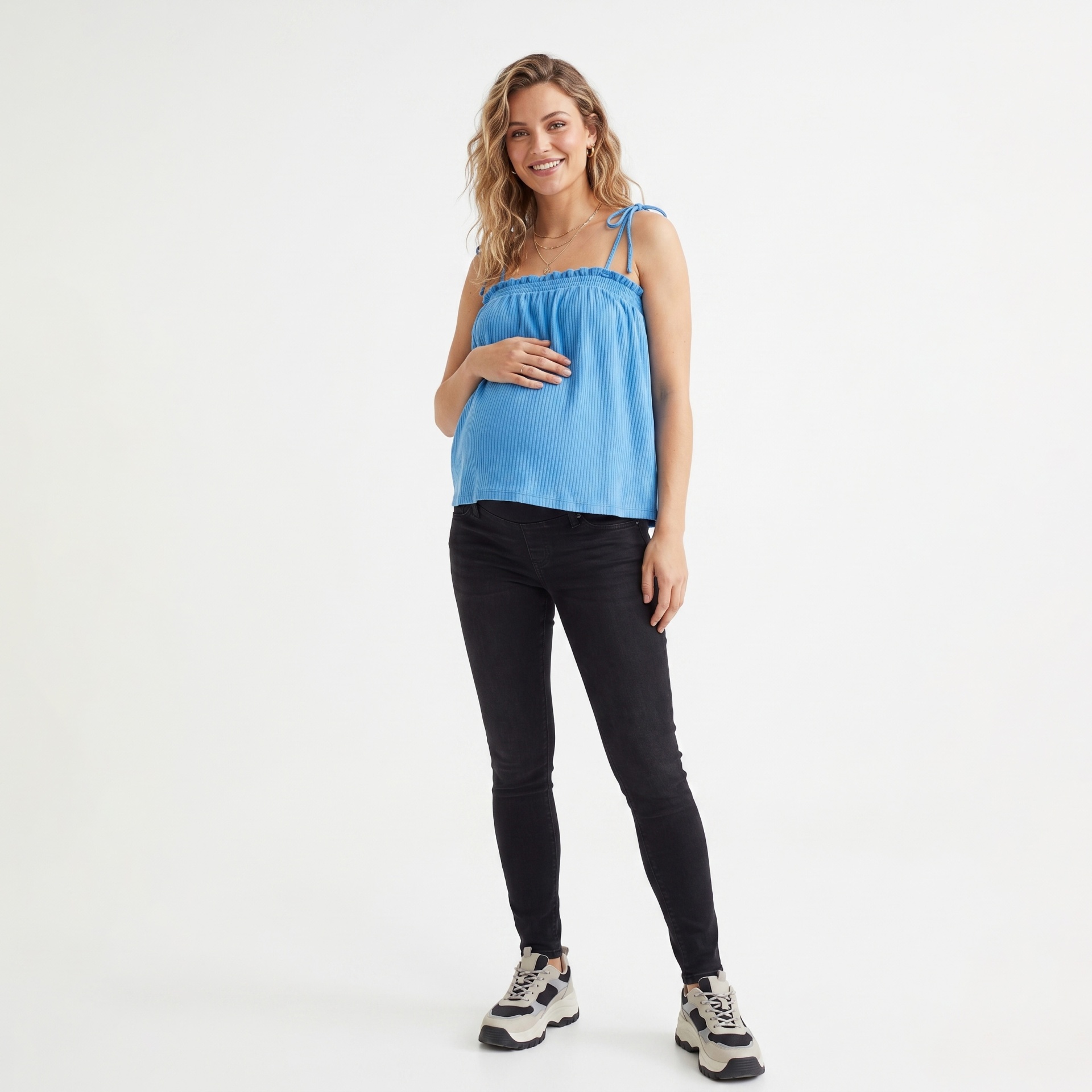 Mulher grávida com blusa azul e calças pretas