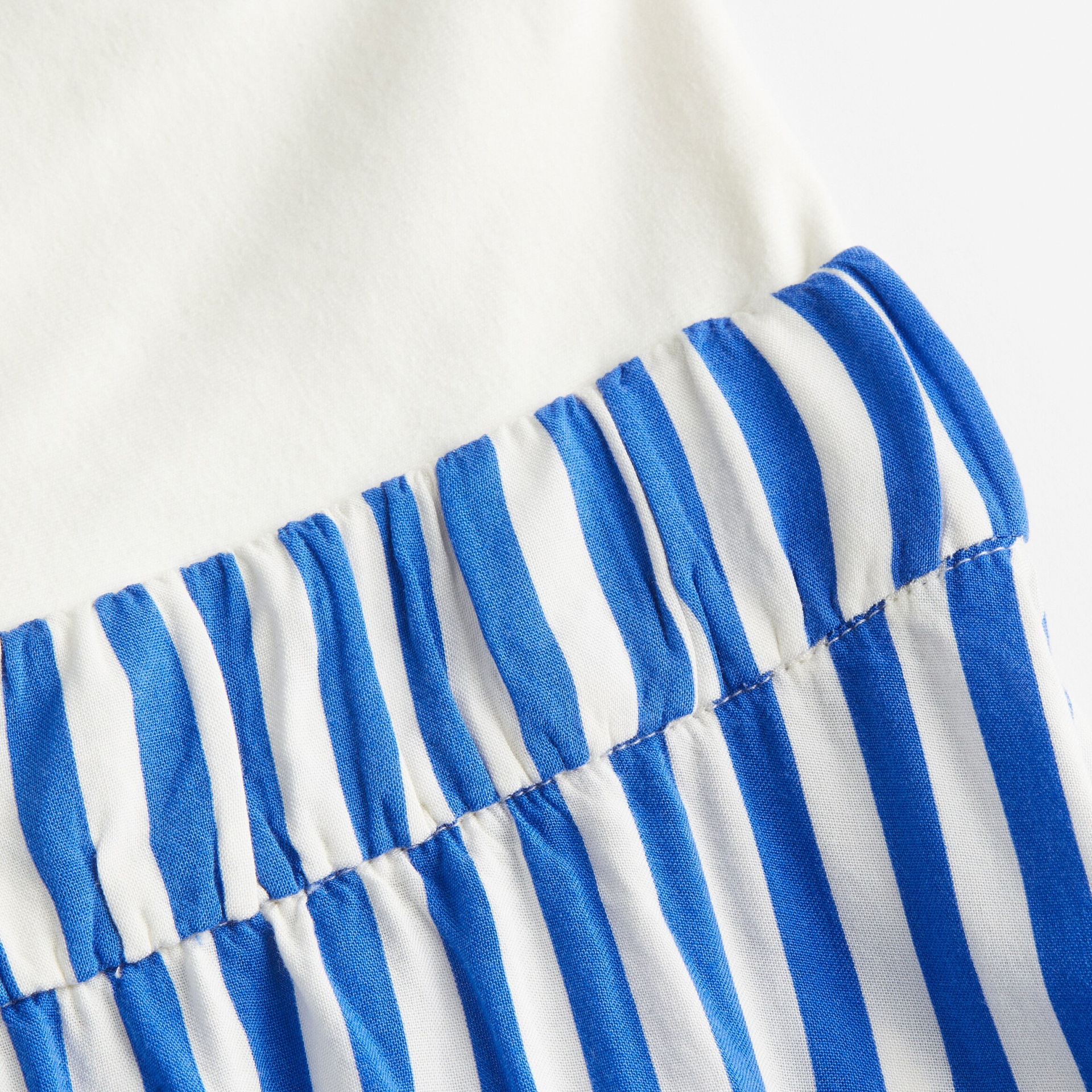 Detalhe de tecido azul e branco com riscas e franzidos