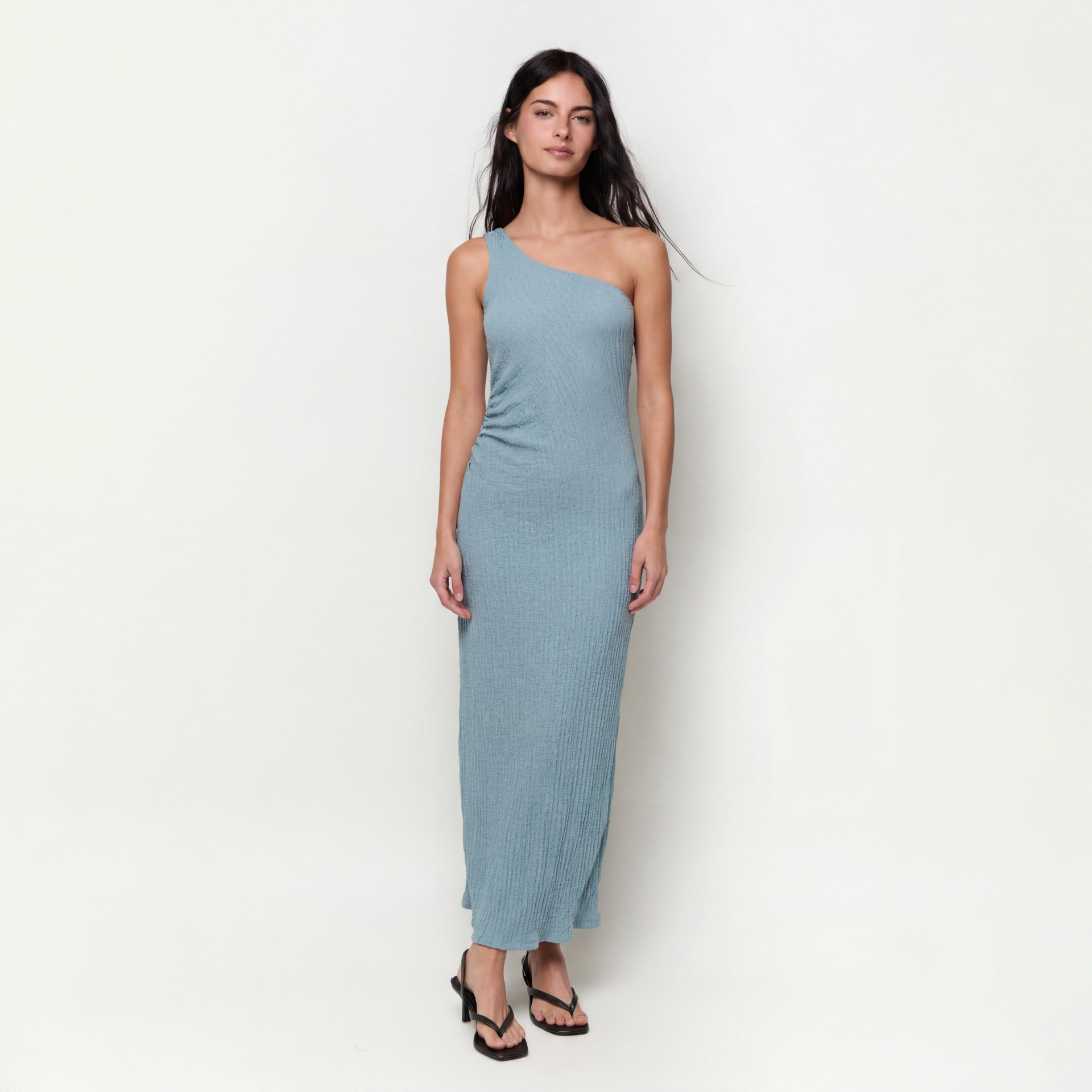 Vestido azul claro de um ombro só em tecido texturado com sapatos de salto pretos