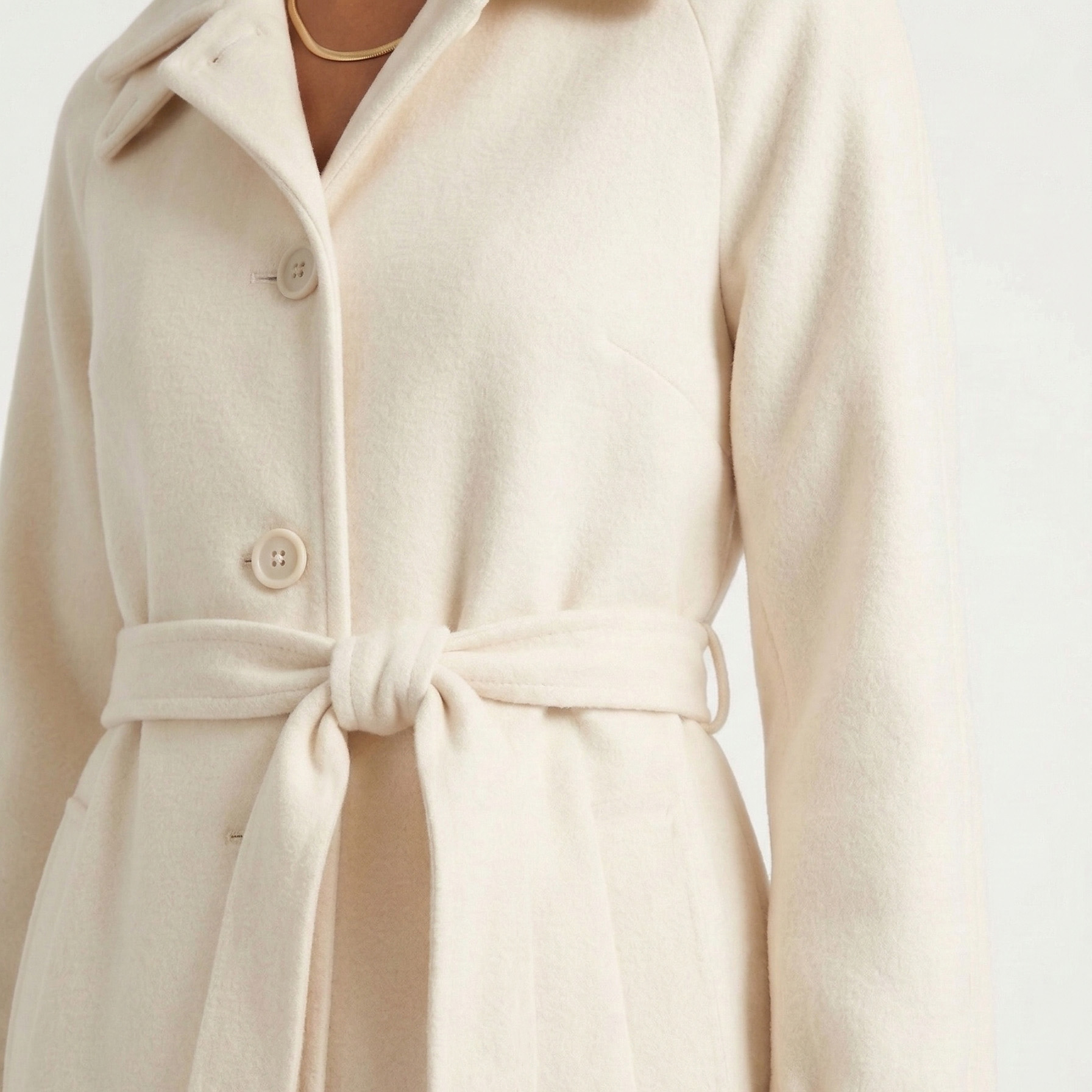 Casaco bege claro com botões e cinto amarrado