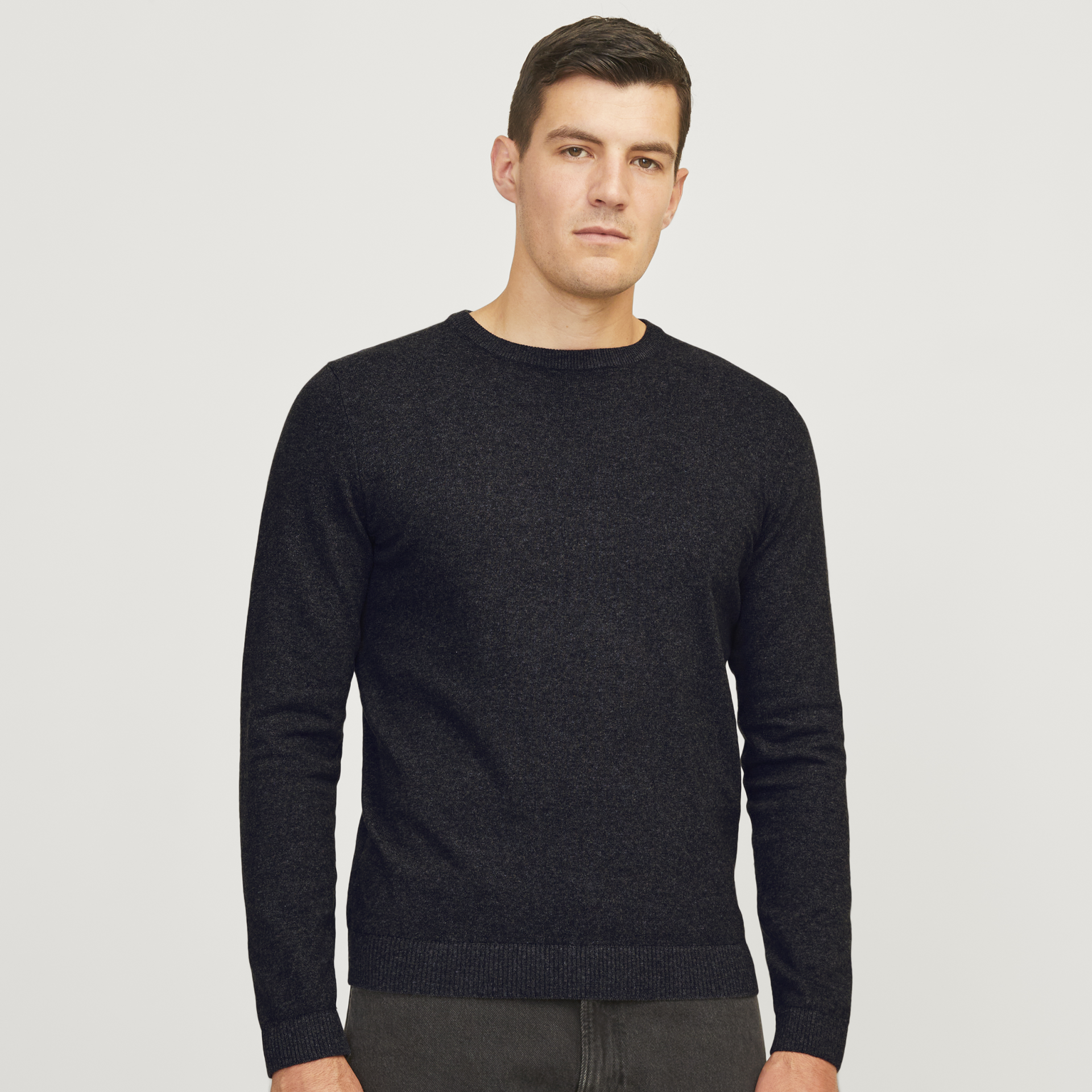Homem a vestir camisola preta de malha com gola redonda