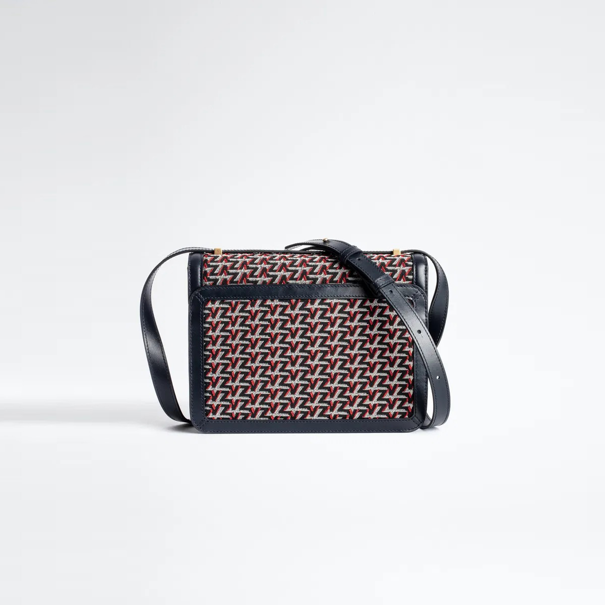 Mala tiracolo padrão geométrico vermelho, preto e branco com correia preta.