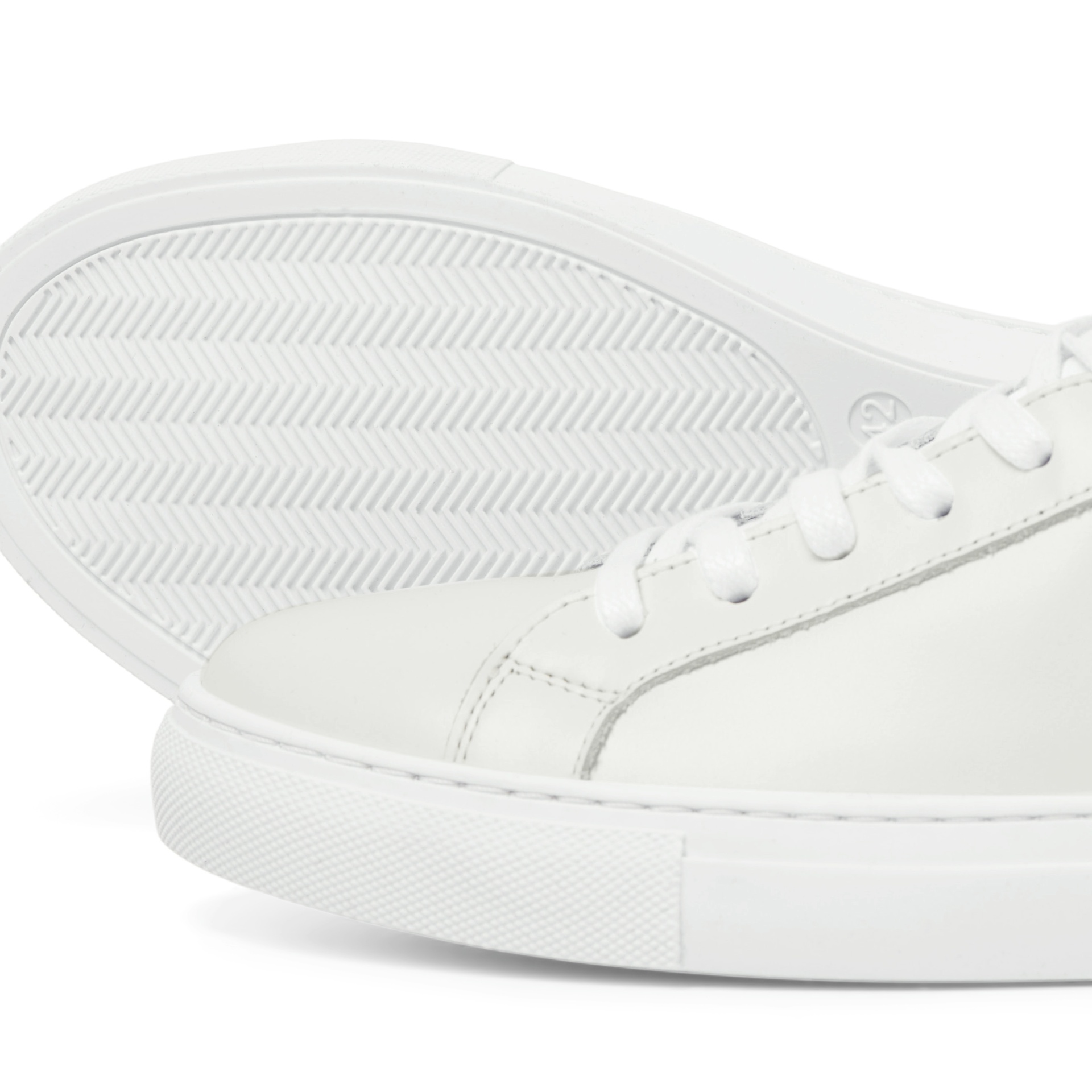 Ténis brancos com sola antiderrapante em padrão zig-zag