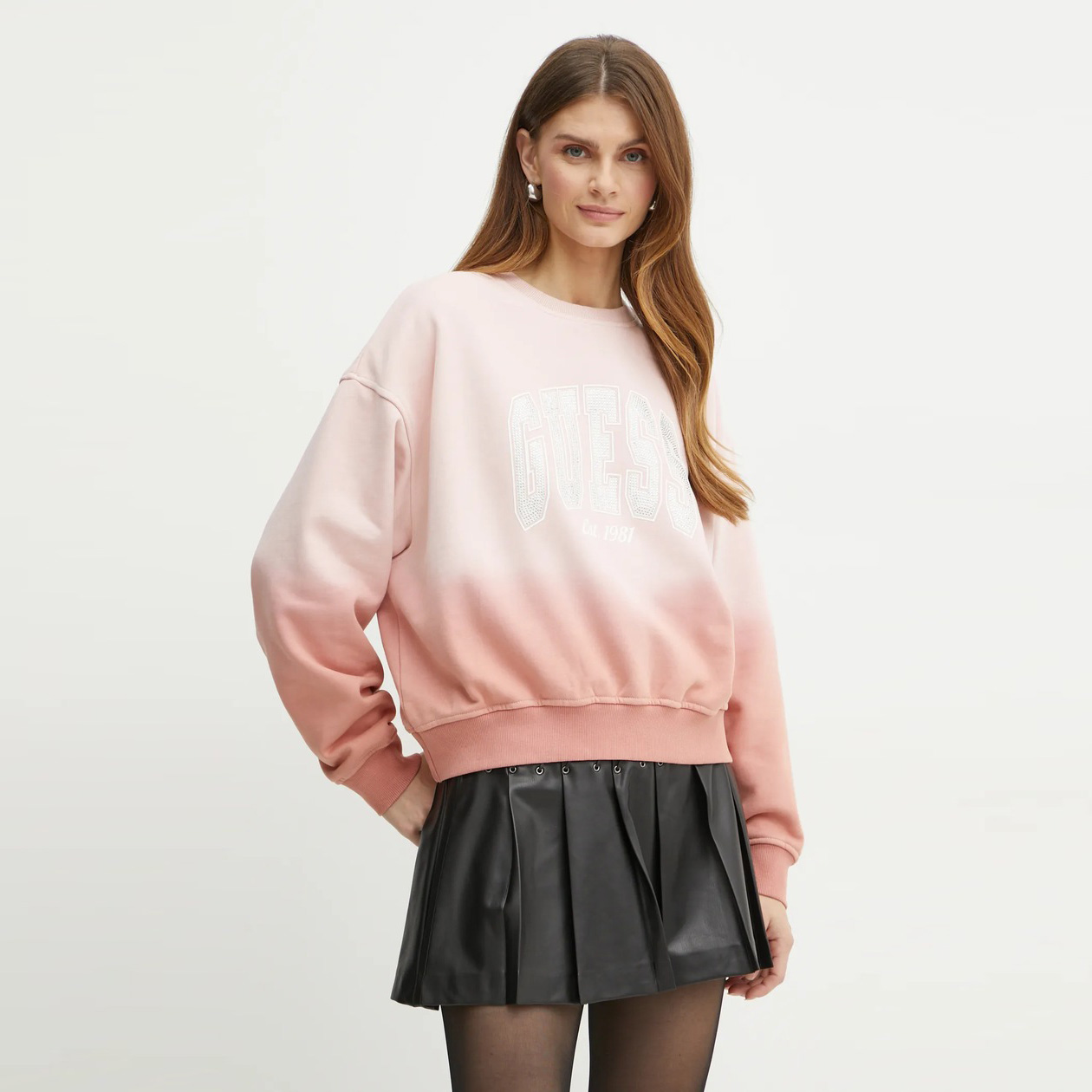 Mulher a usar sweatshirt rosa GOTESS e saia preta plissada em fundo branco
