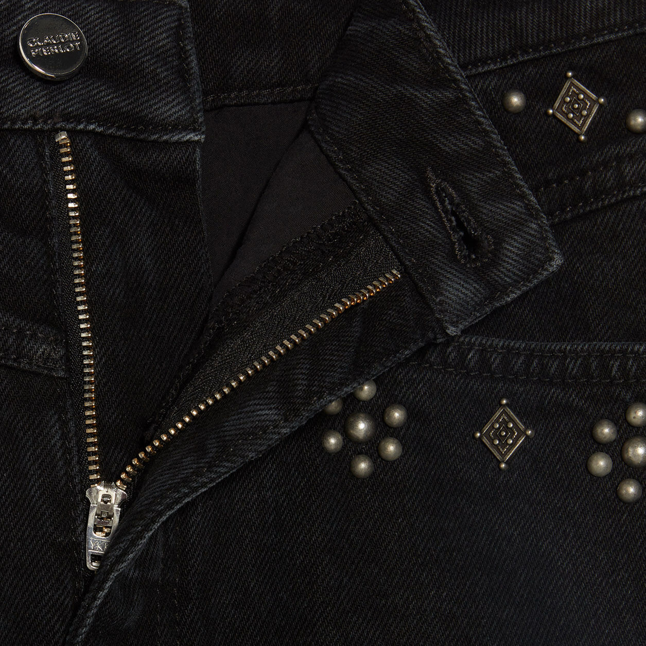 Peça de ganga preta com fecho metálico, botão CLAUDIE PIERLOT e tachas prateadas