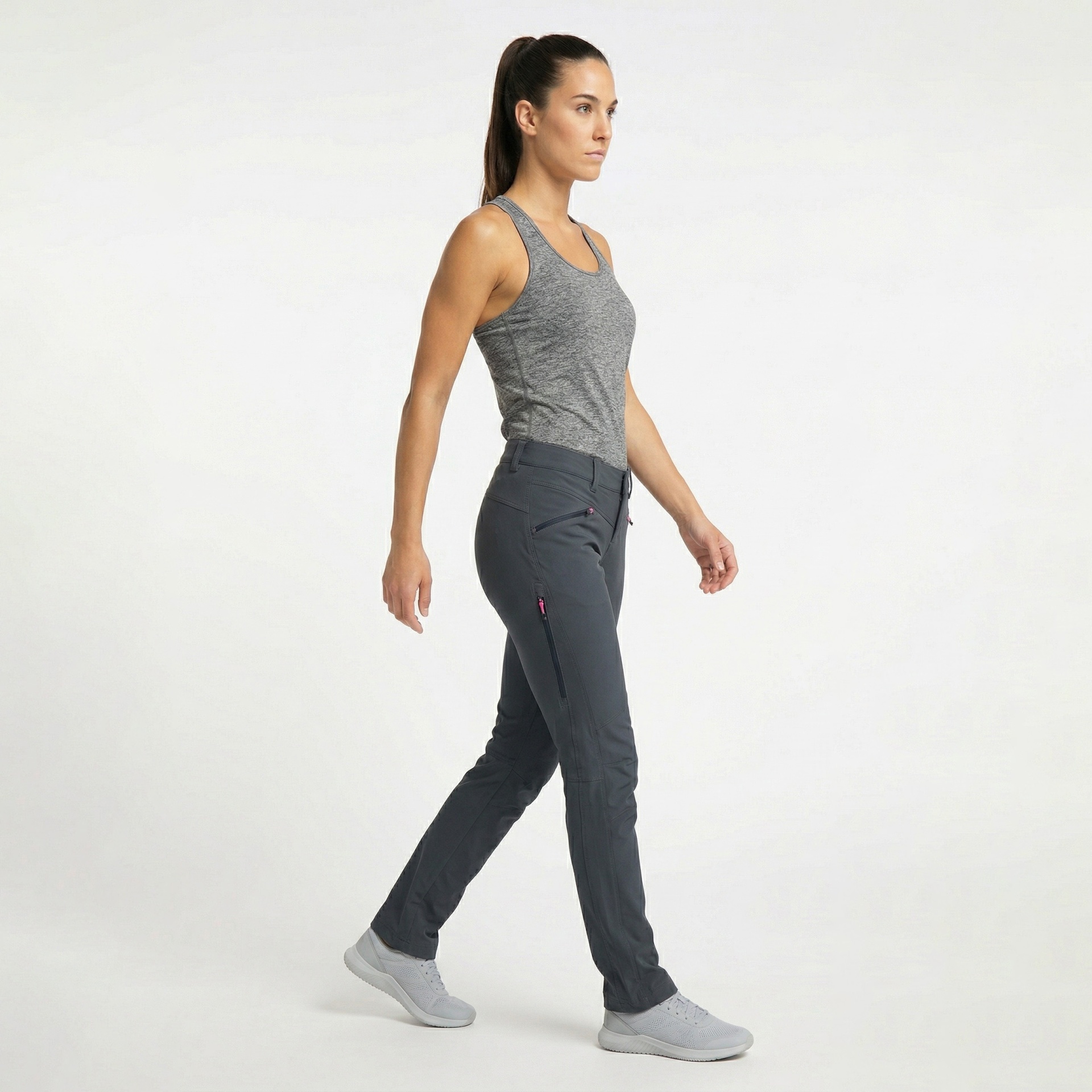 Mulher vestindo roupa desportiva cinza com calças e top em fundo branco