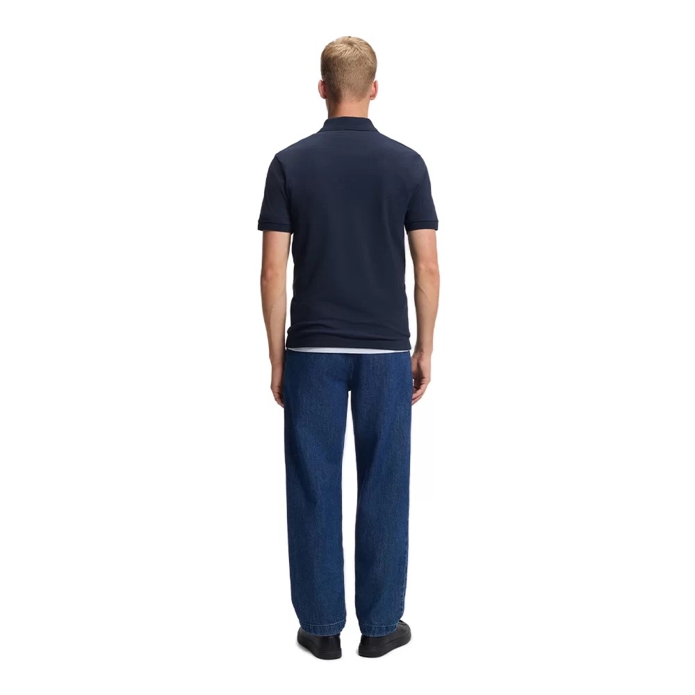 Homem de costas com polo azul escuro e calças de ganga azul