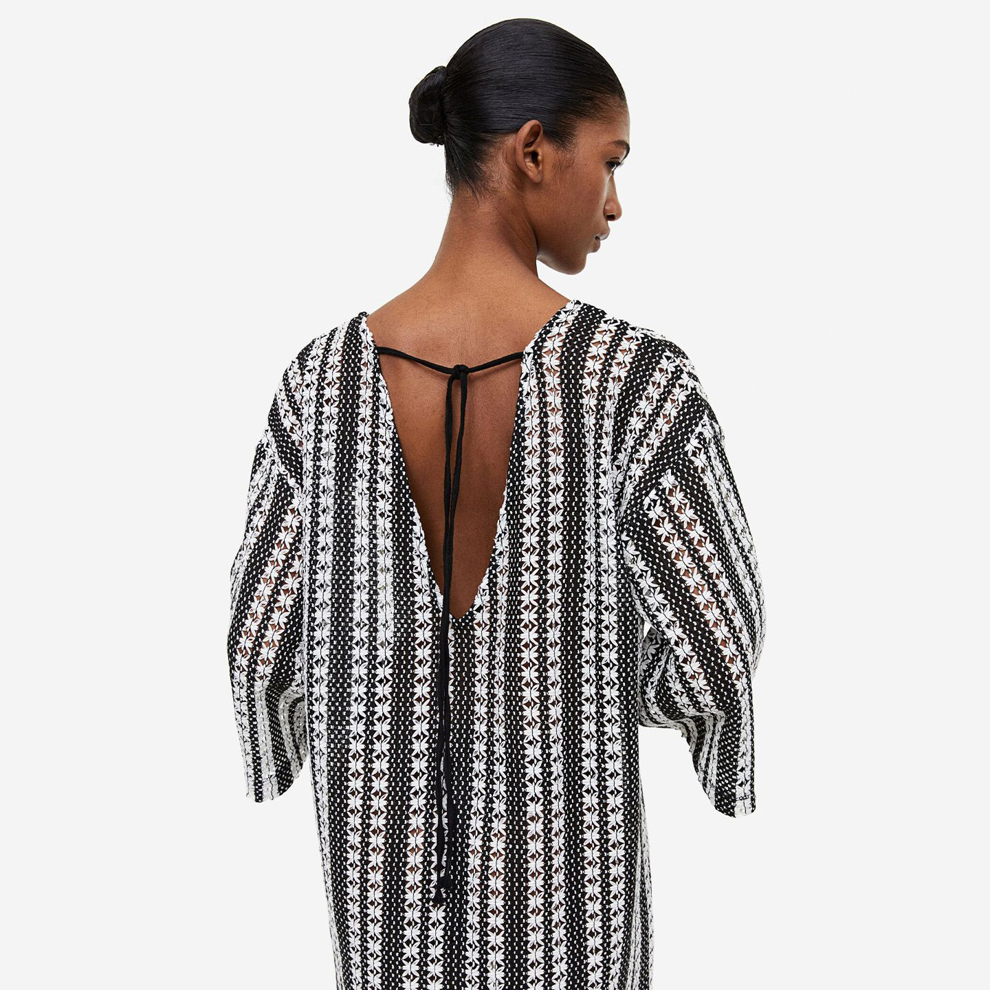 Blusa feminina preta e branca com padrão floral e decote em V às costas