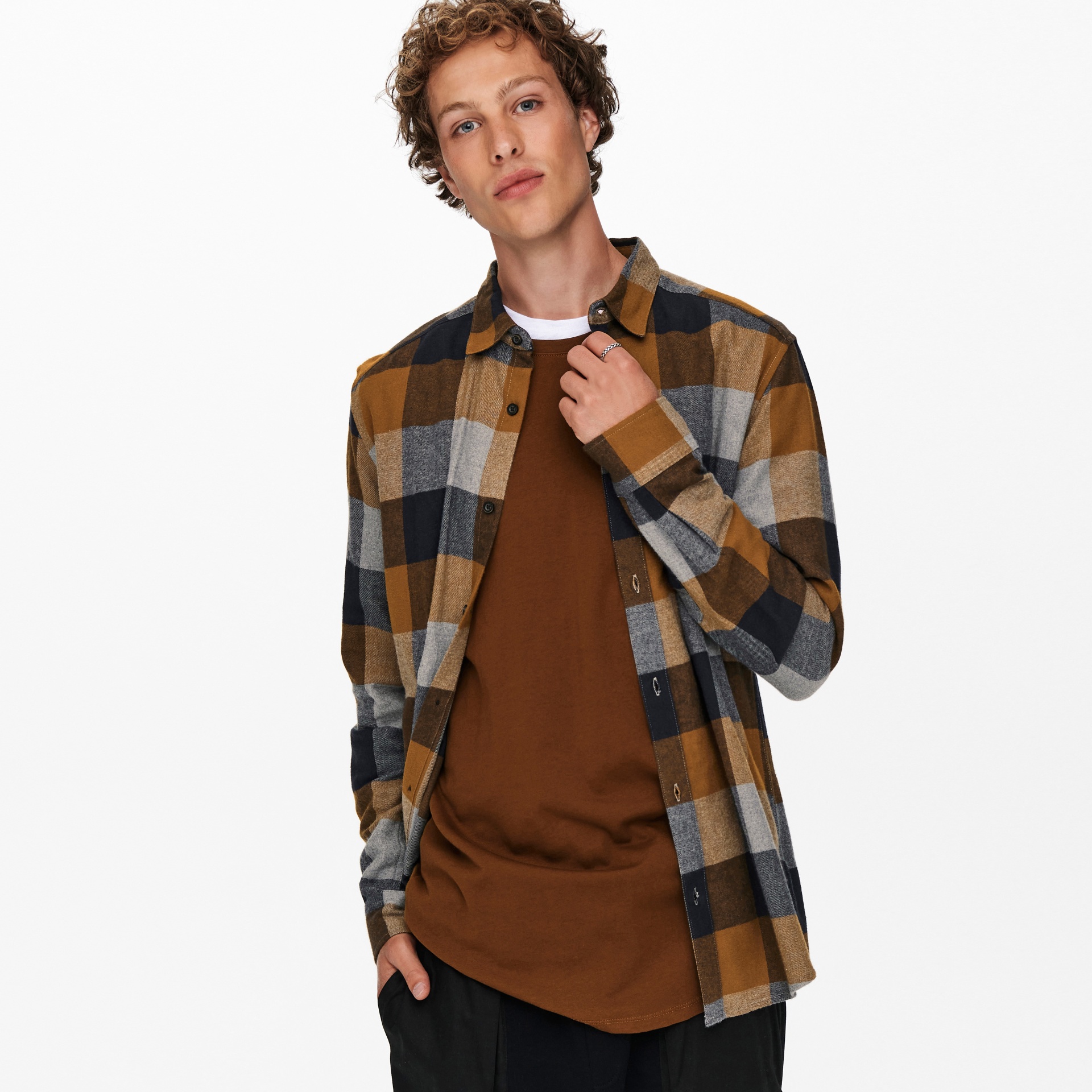 Homem com camisa xadrez castanha e cinza sobre t-shirt castanha