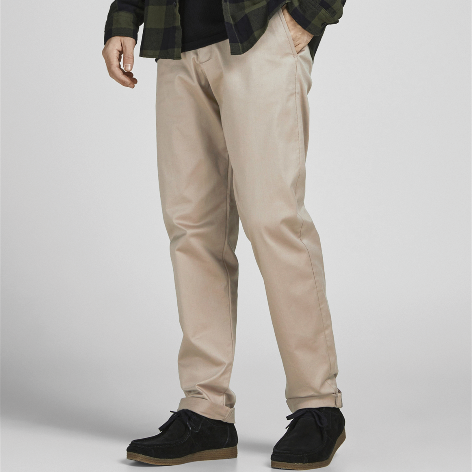 Calças bege claras, sapatos pretos, camisa xadrez verde escura e t-shirt preta