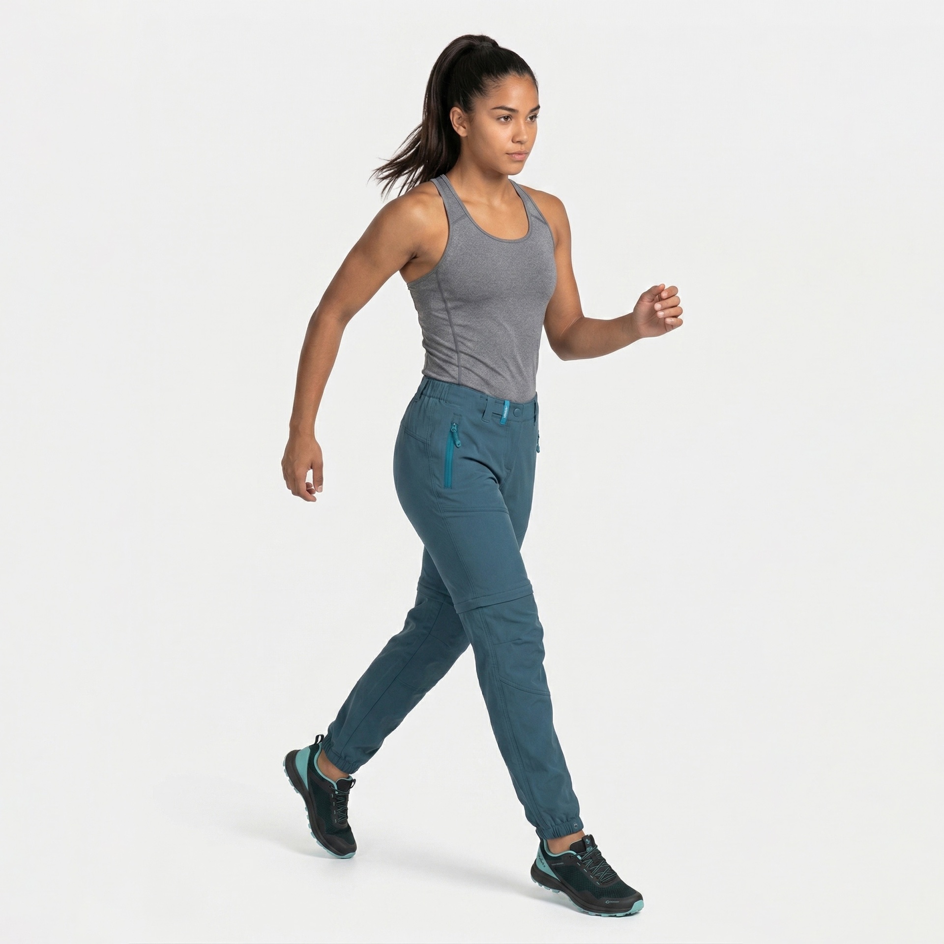 Mulher a caminhar com top cinza e calças azuis em fundo branco