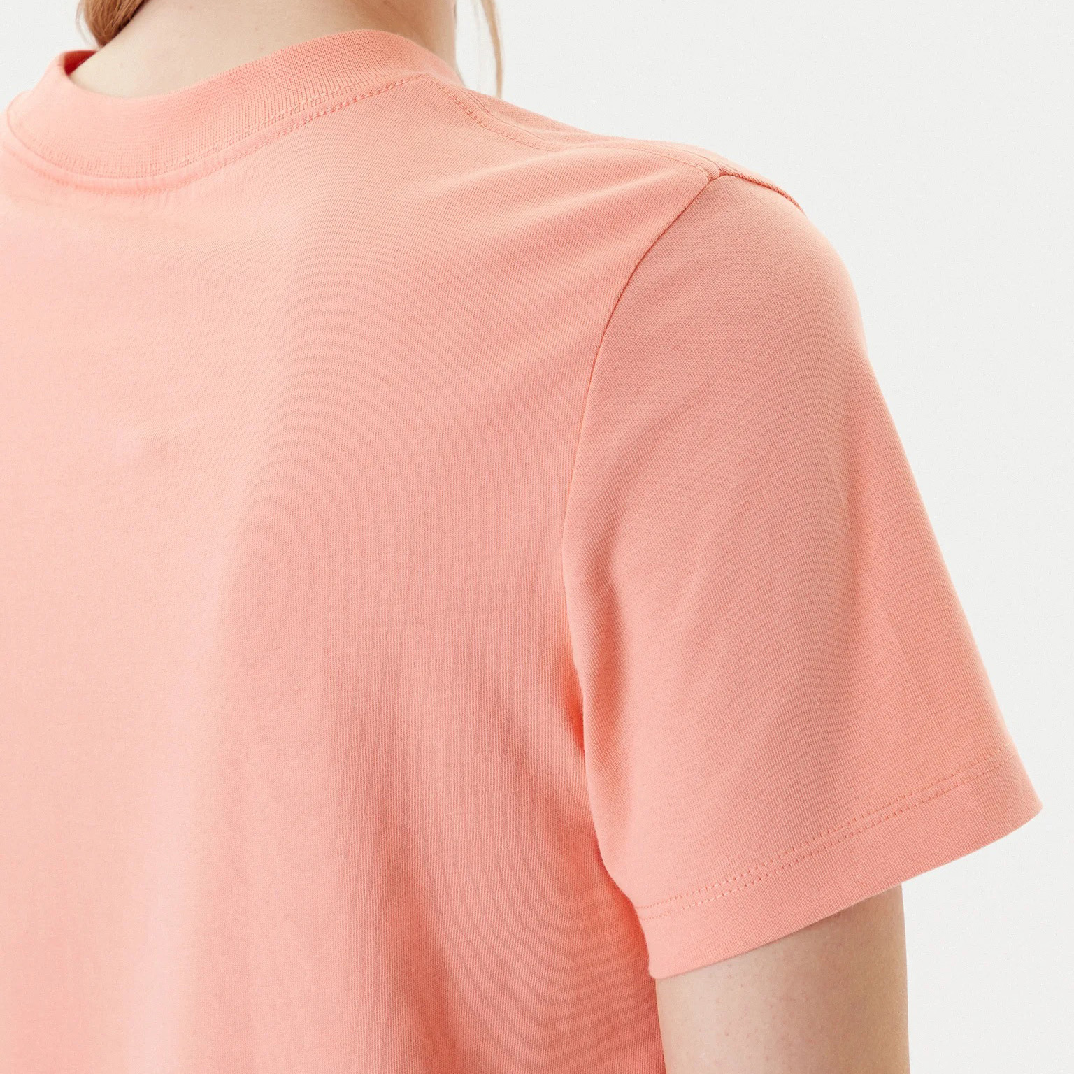 T-shirt feminina cor de salmão vista de costas até os ombros