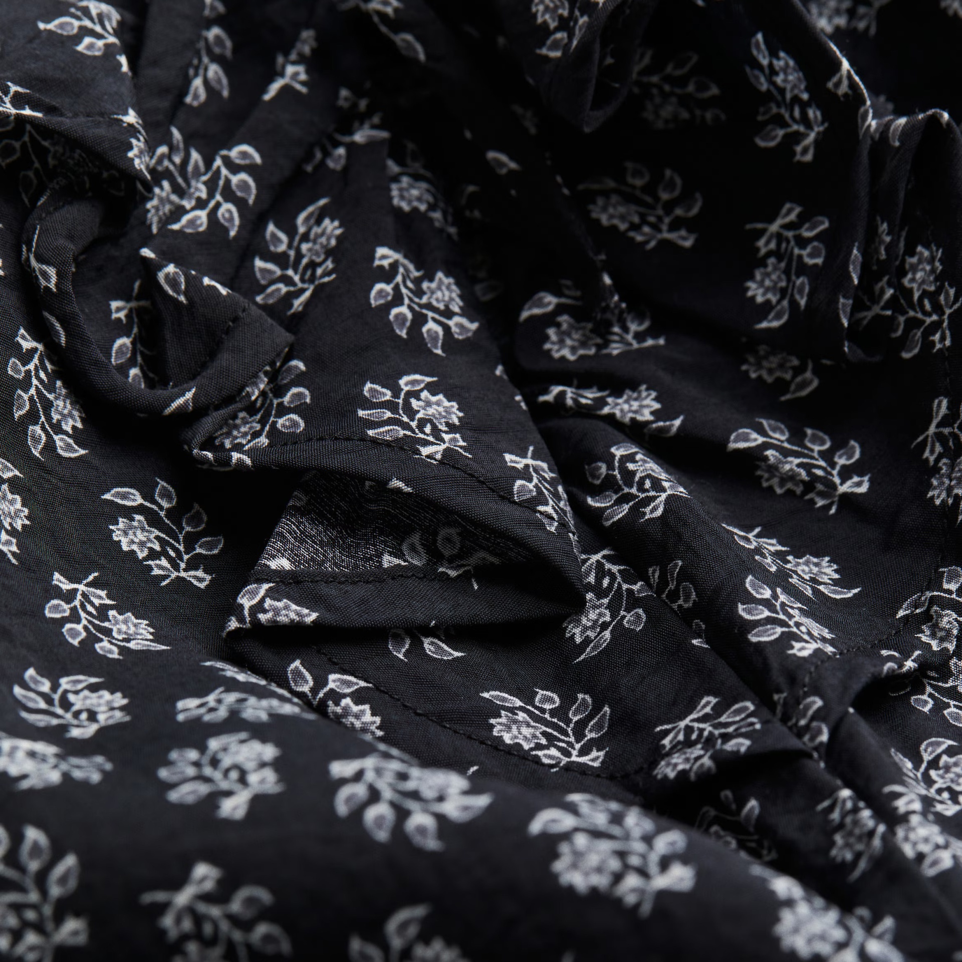 tecido preto com padrão floral branco