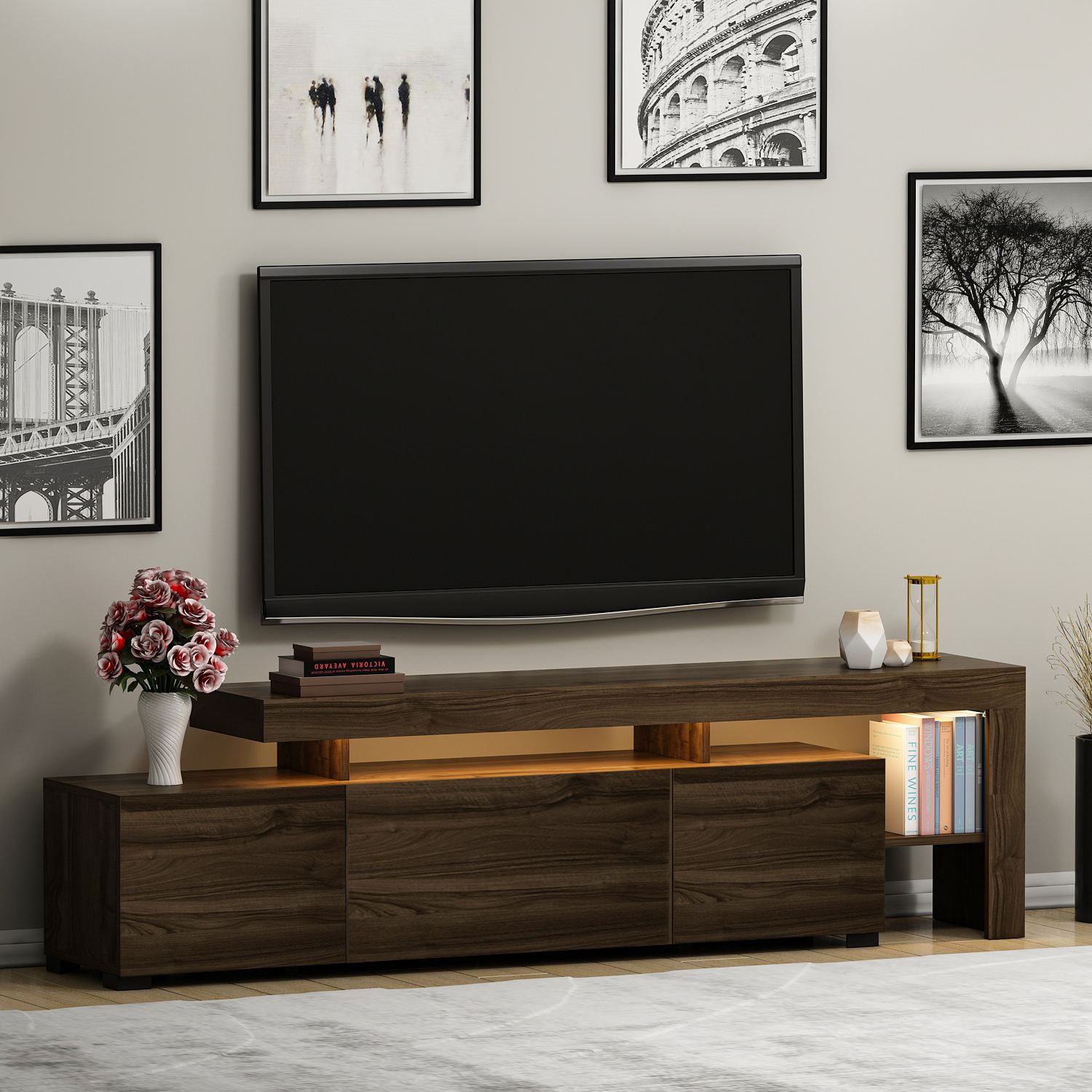 Móvel para televisão em madeira escura com objetos decorativos e televisão preta na parede com quadros a preto e branco