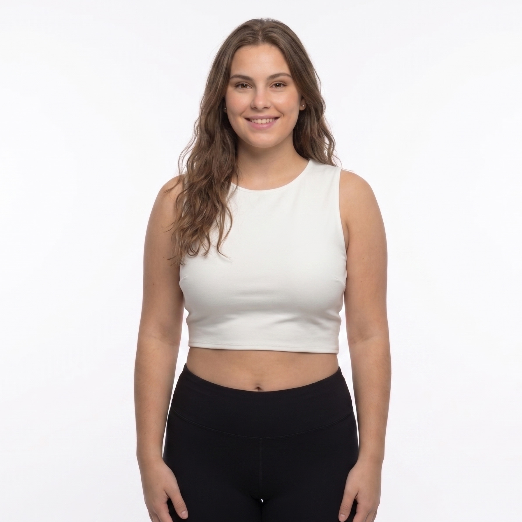 Mulher com camisola cropped branca e calças pretas em fundo branco