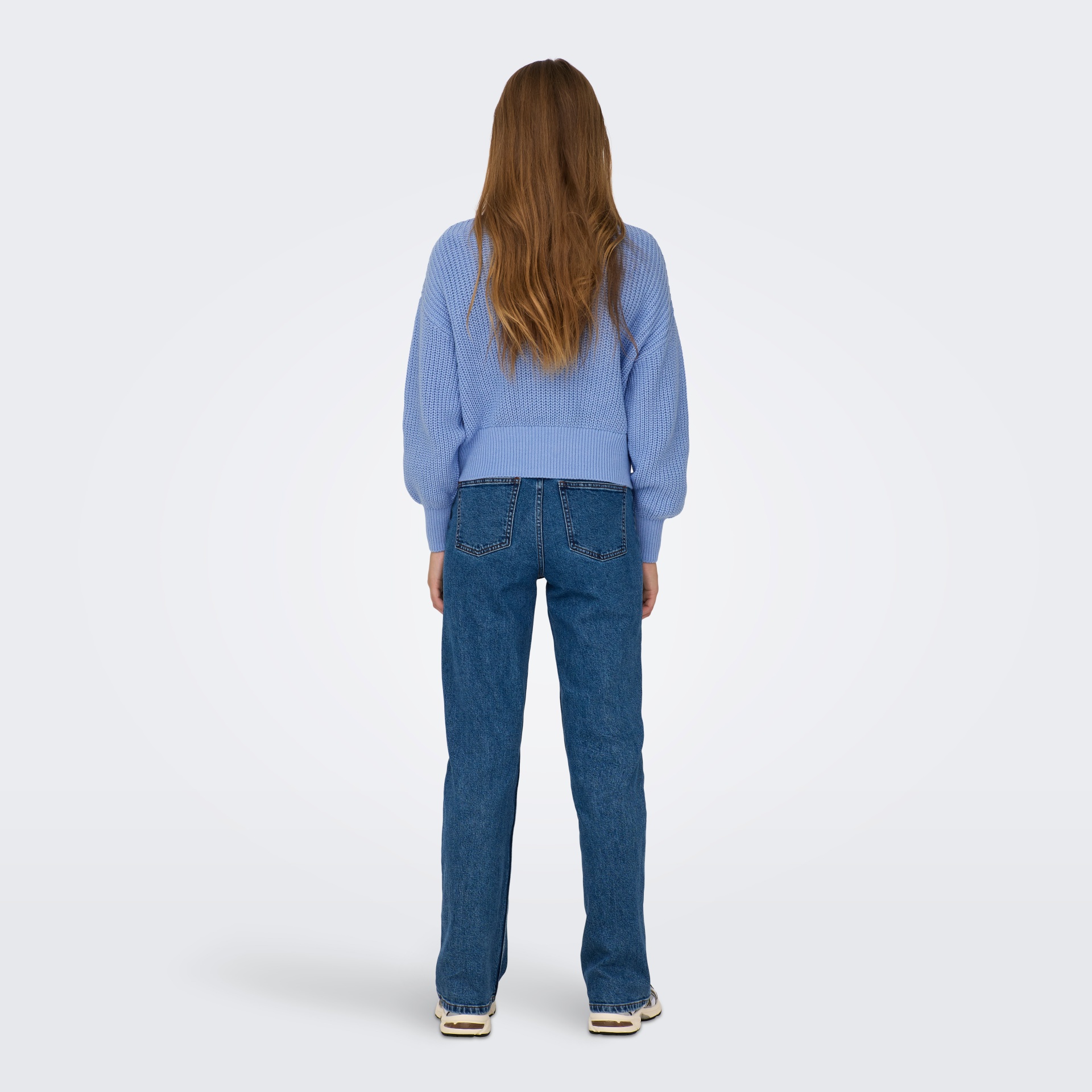 Mulher de costas com camisola azul e calças de ganga