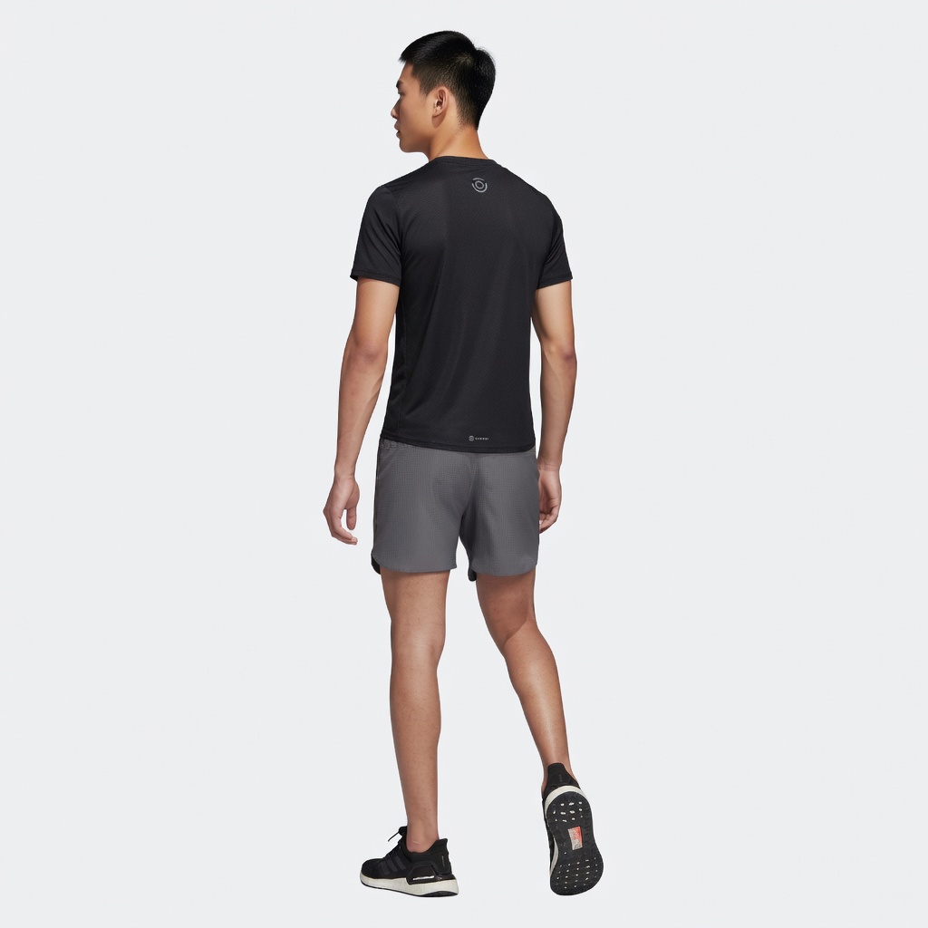 Homem de costas com t-shirt preta, calções cinza e sapatilhas pretas