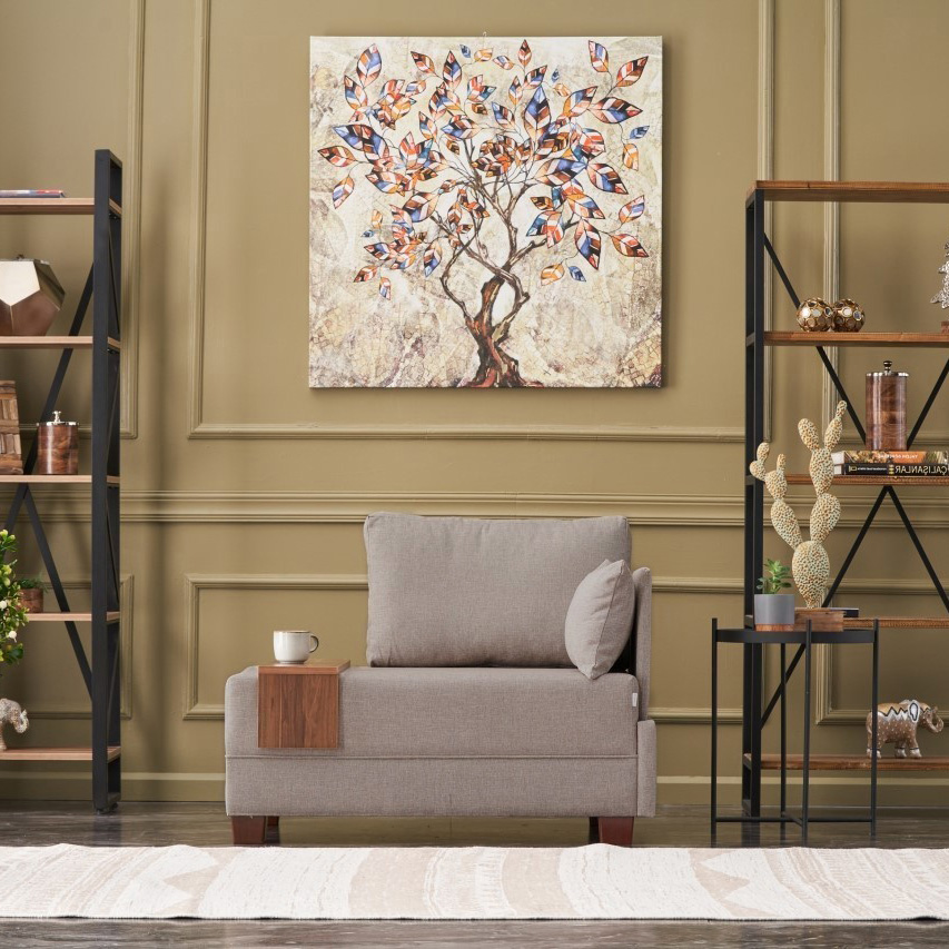 Sala com sofá individual cinza, quadro de árvore colorida e estantes decorativas.
