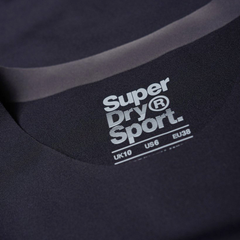 Etiqueta branca com texto Super Dry® Sport num tecido preto