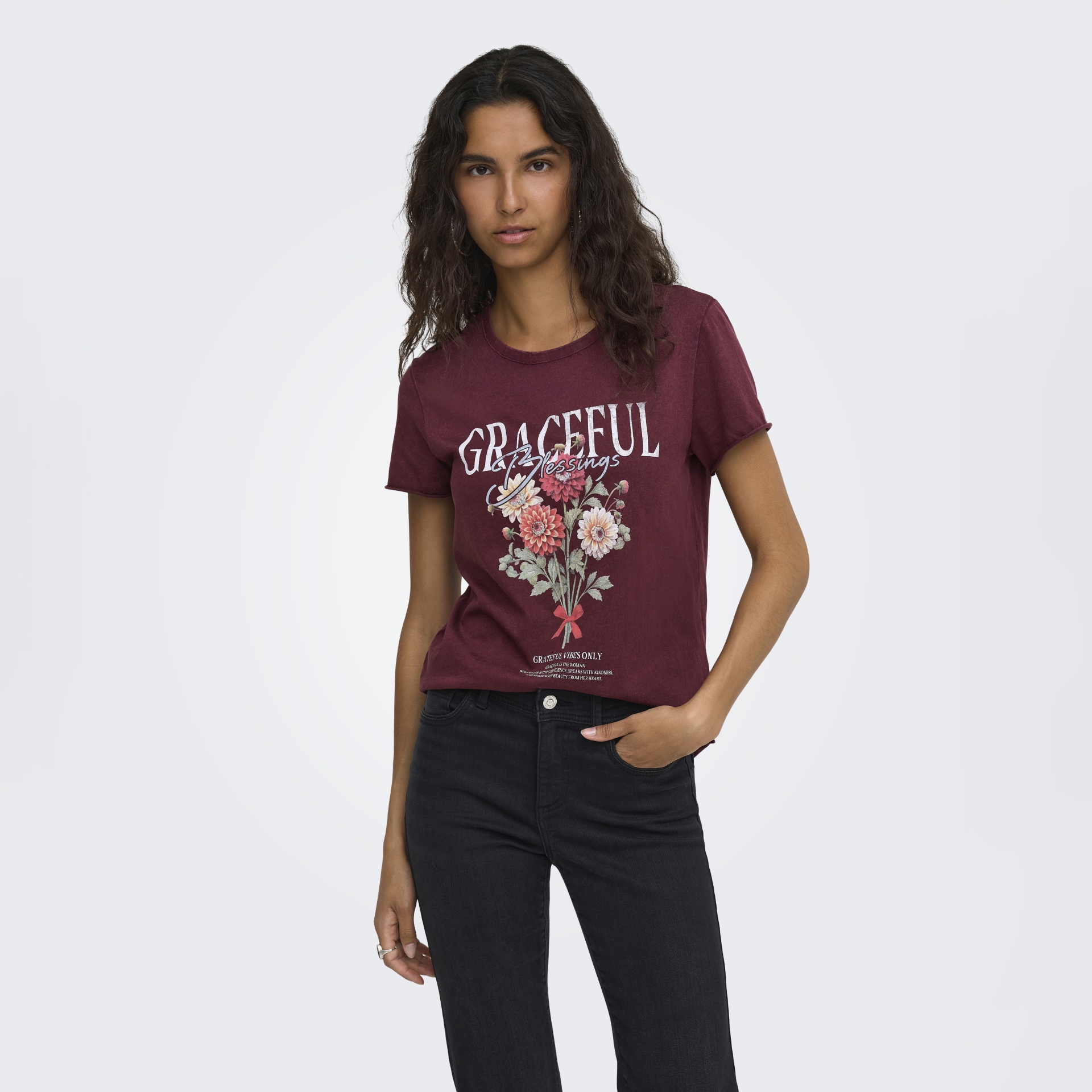 T-shirt borgonha com estampa floral e texto, usada por modelo jovem