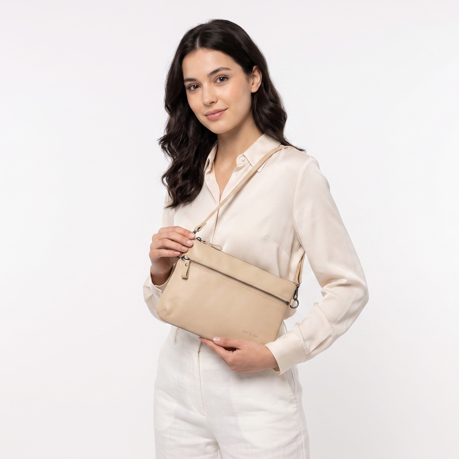 Mulher com bolsa pequena bege em fundo branco