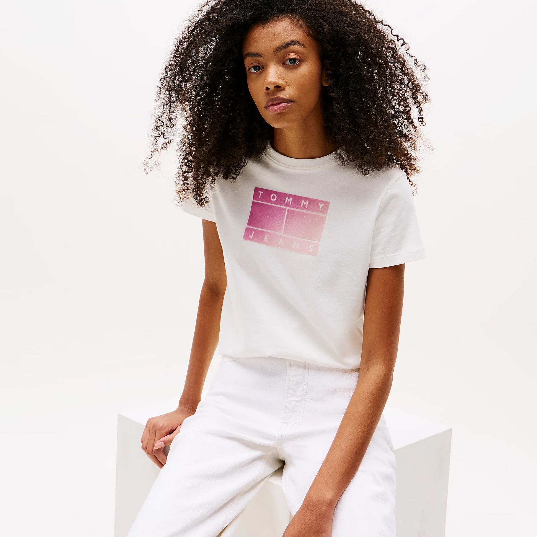 T-shirt branca Tommy Jeans com estampado rosa e calças brancas