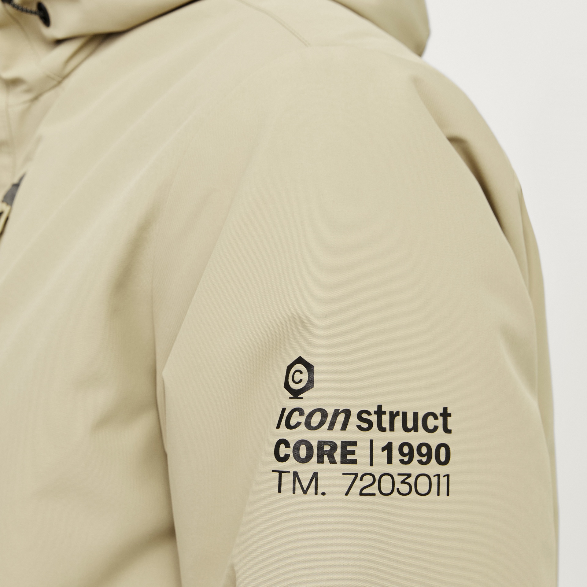 Casaco bege com logótipo e texto impresso no braço