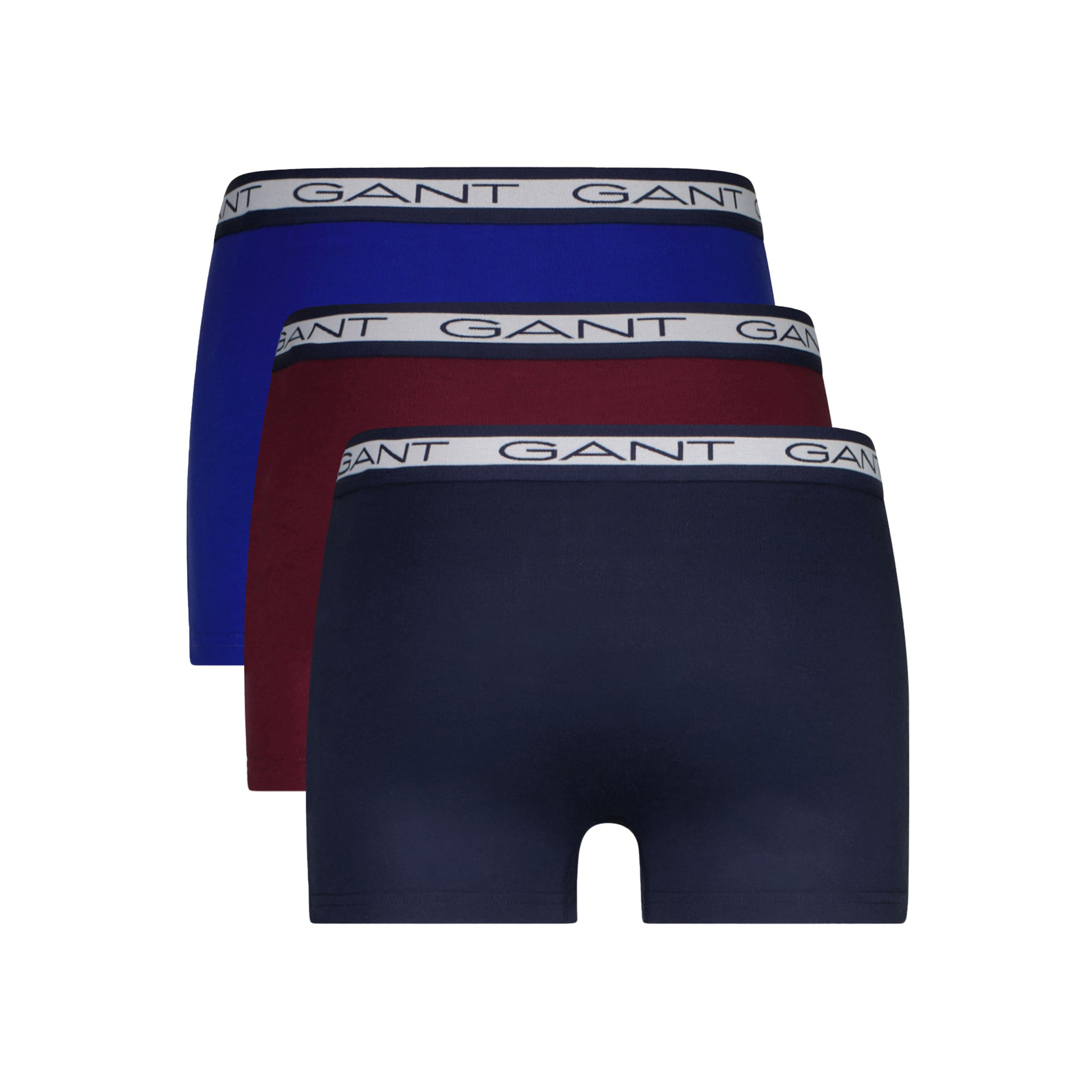 Três cuecas boxer GANT em azul escuro, vermelho e azul royal com elástico branco e marca na cintura.