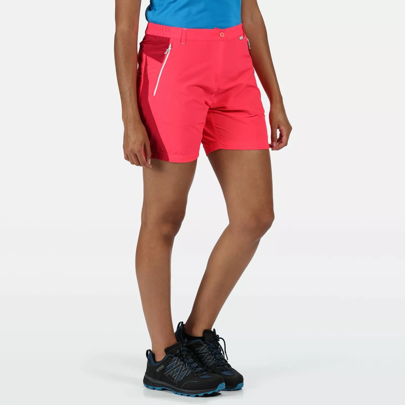 Mulher a usar calções rosa, ténis pretos e camiseta azul