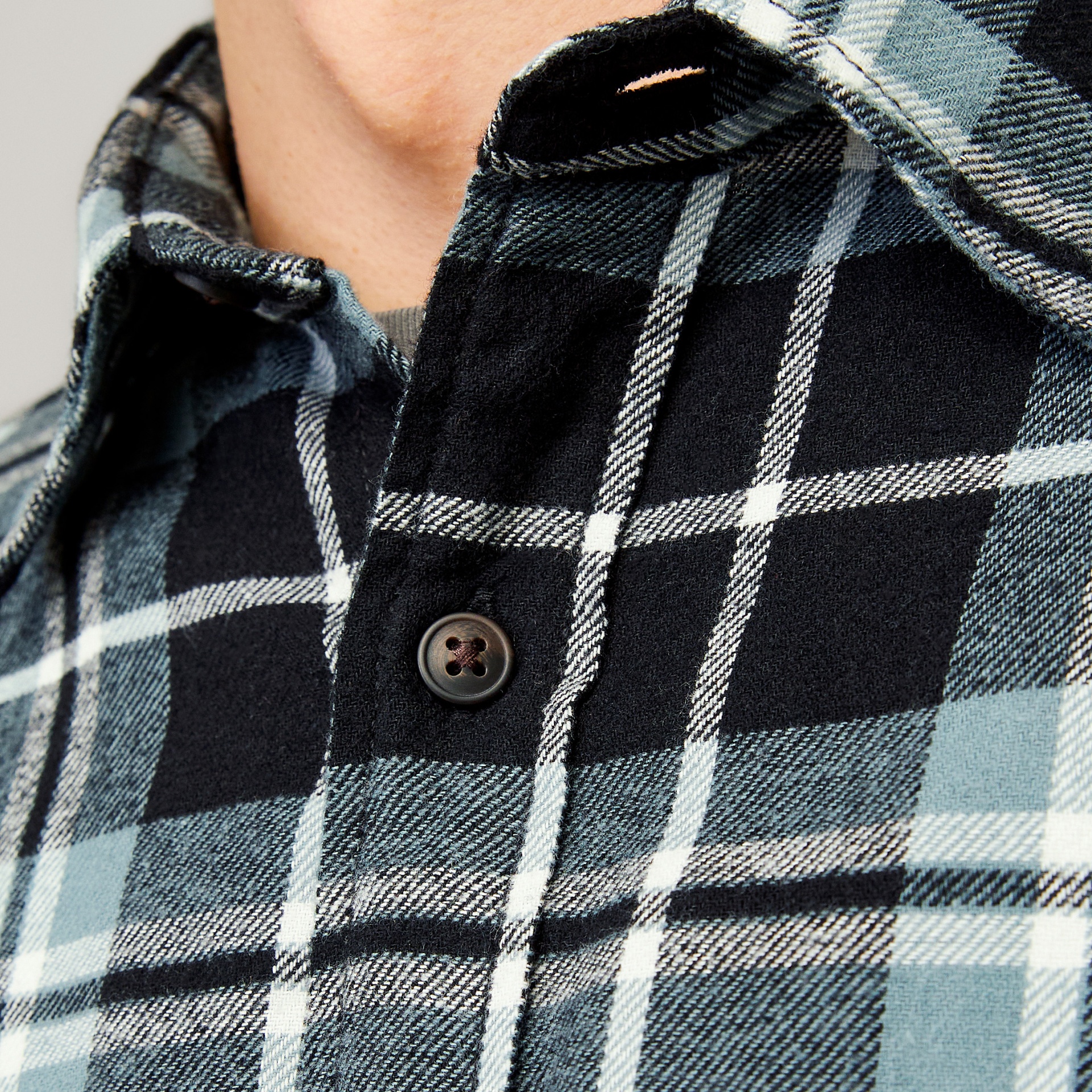 Camisa xadrez preto, branco e azul com botão preto